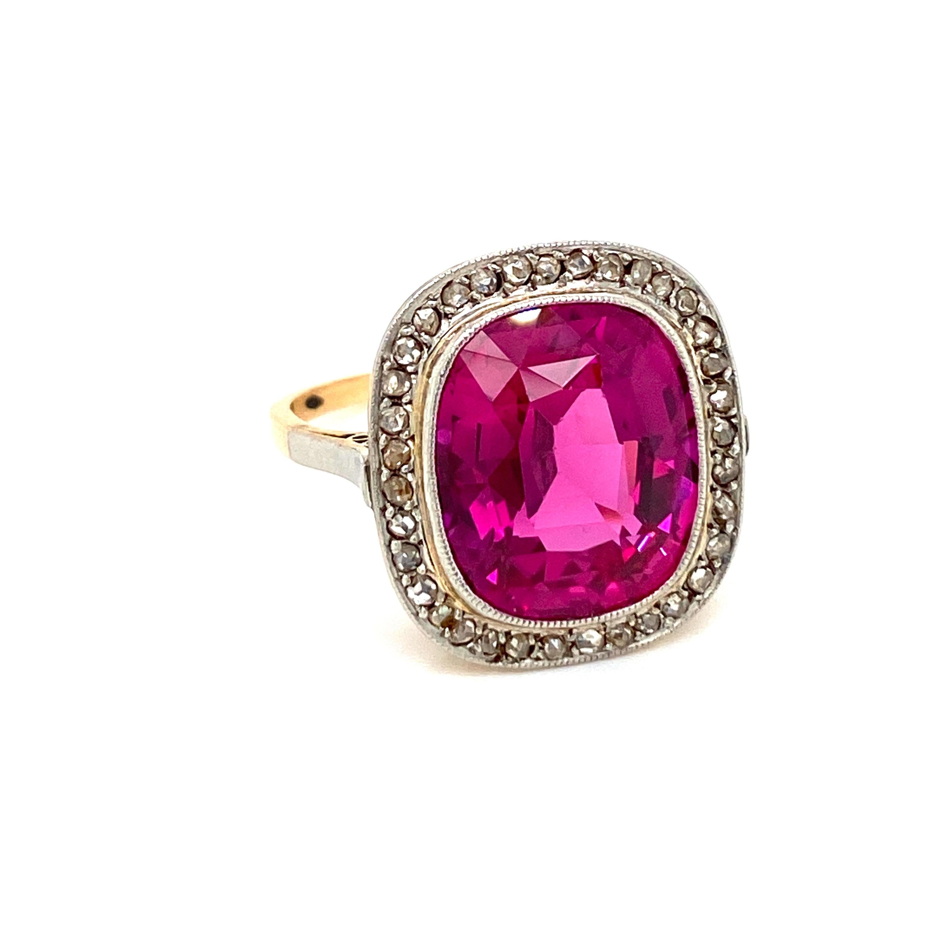 Antique 18K rose Gold Verneuil Synthetic Ruby and Diamond ring. 
The cluster style ring is centered with an approximately 6 carat stunning oval synthetic ruby, see note below, accented by an halo of old cut diamonds weighing approx. 0,40 carats