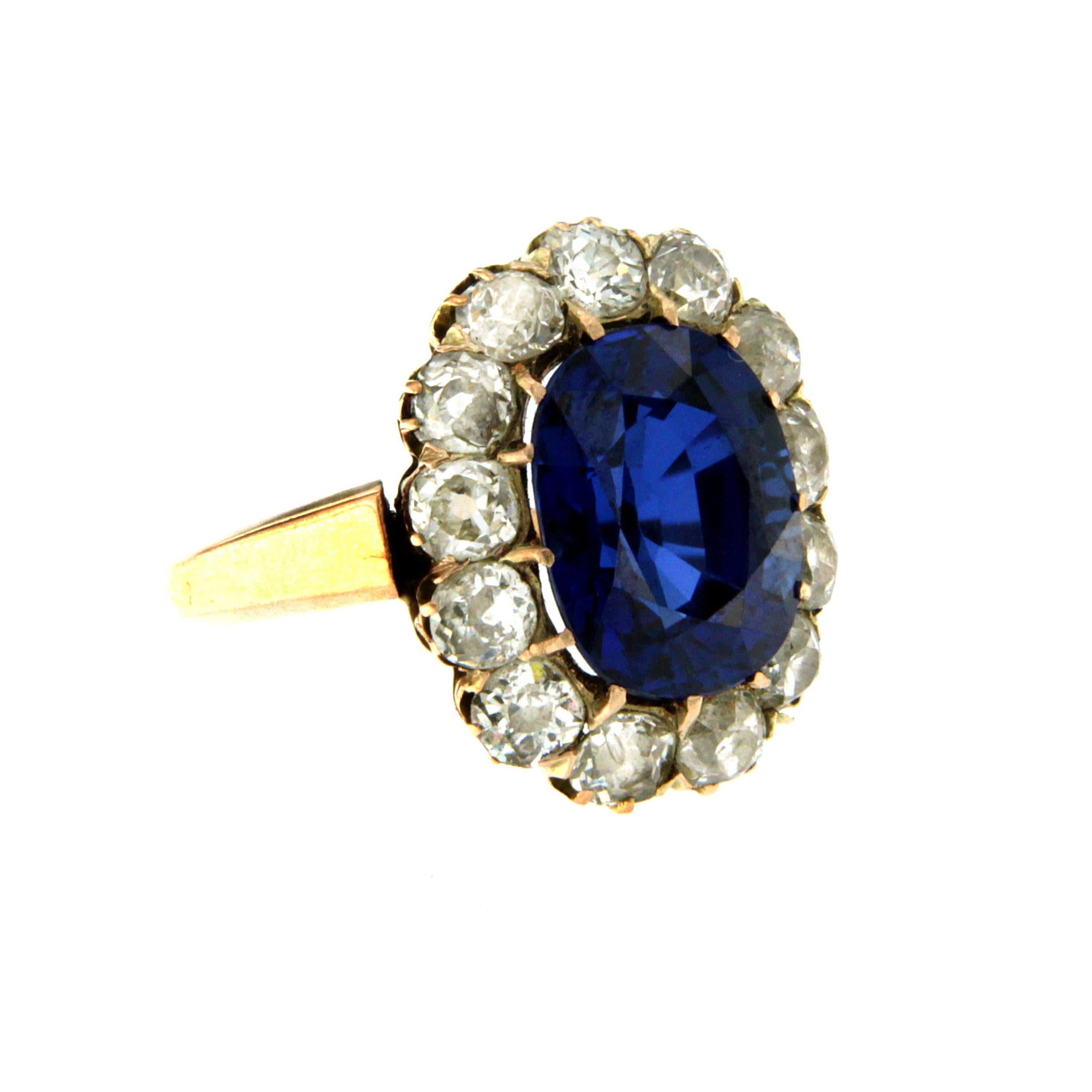 Antique 18K rose Gold Verneuil Synthetic Sapphire and Diamond ring. 
The cluster style ring is centered with an approximately 6 carat royal blue oval synthetic sapphire, see note below, accented by 13 rose cut diamonds weighing approx. 3 carats