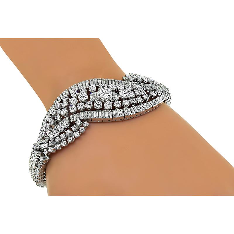 This is an elegant platinum bracelet. The bracelet is centered with a sparkling round cut diamond that weighs approximately 1.00ct. The color of the diamond is K-L with VS clarity. The center diamond is accentuated by dazzling round and baguette cut
