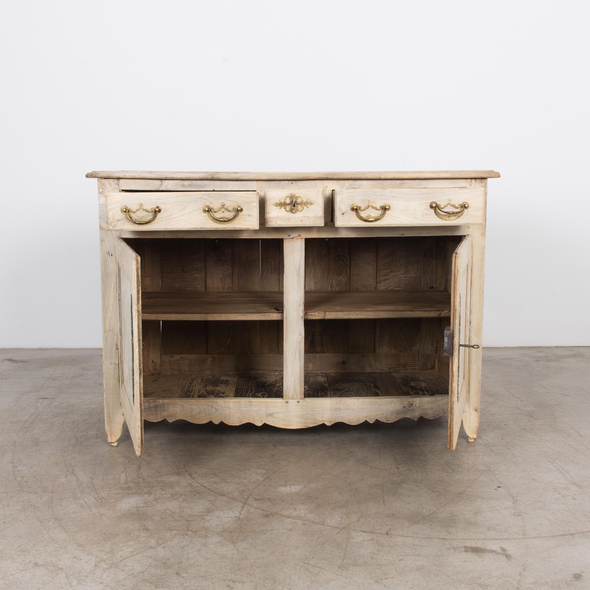 Transport your space to the refined splendor of the 1800s with the Belgian Bleached Oak Buffet, a testament to timeless elegance. The very light oak finish imparts a subtle and sophisticated glow. Atop this exquisite buffet, three drawers provide