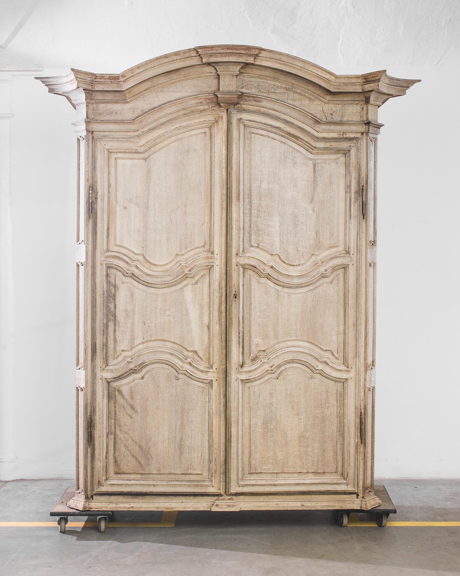 Made in a neo-classicist epoch, this 19th century Belgian armoire mesmerizes with the perfection of its contours. The angular crown boasts an impressive cavetto molding, composed of multiple tiers of mitered corners. Following the solemn outlines of