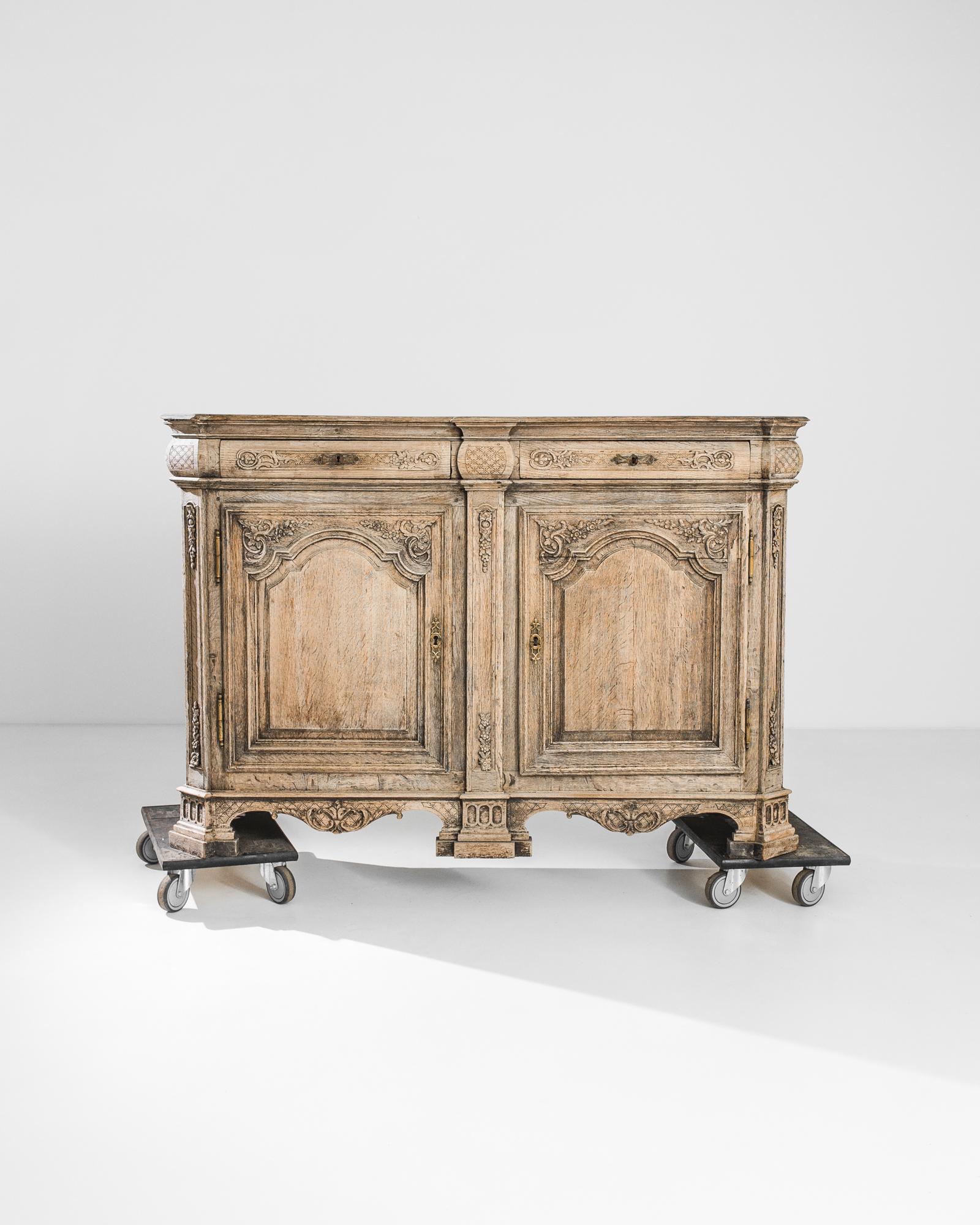 Abundant carving and a striking silhouette give this oak buffet an ornate Neo-renaissance aesthetic. Made in Belgium, circa 1800, a pair of serpentine drawers sit atop a faceted cabinet, elevated upon elaborate pedestal feet. The corners of the
