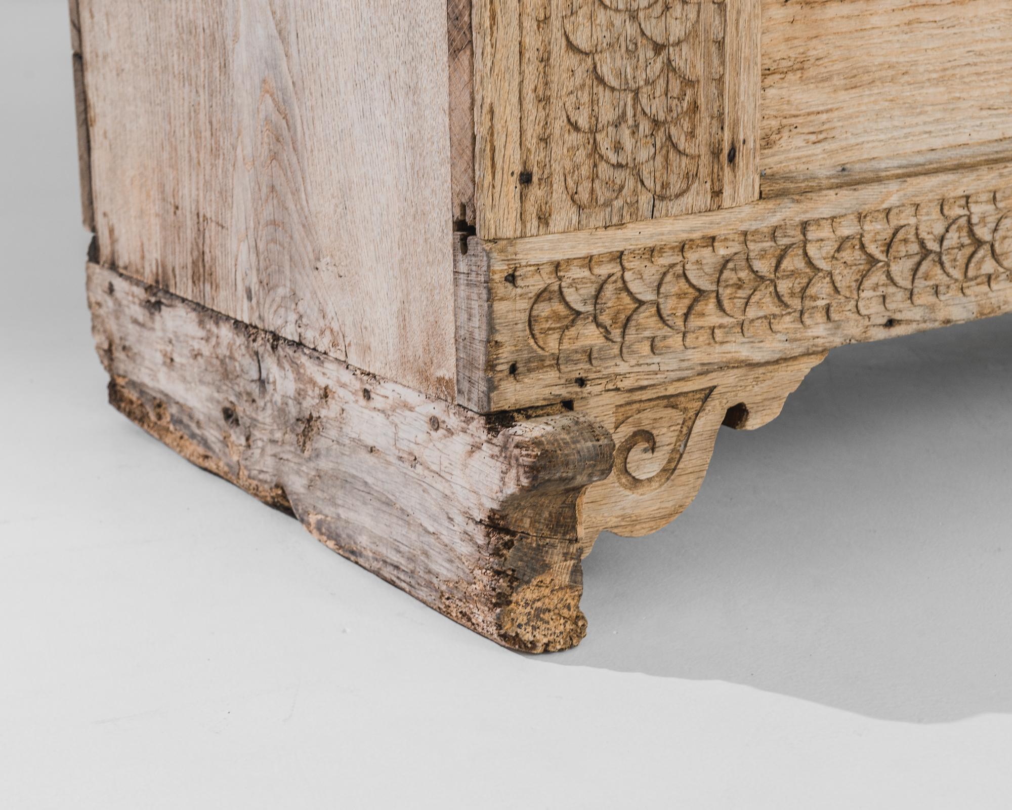 Experience the allure of 19th-century Germany with this provincial wooden trunk. The intricate carvings adorning the charming case weave delicate floral patterns, showcasing the fine craftsmanship of the era. Raised on feet, the trunk features an