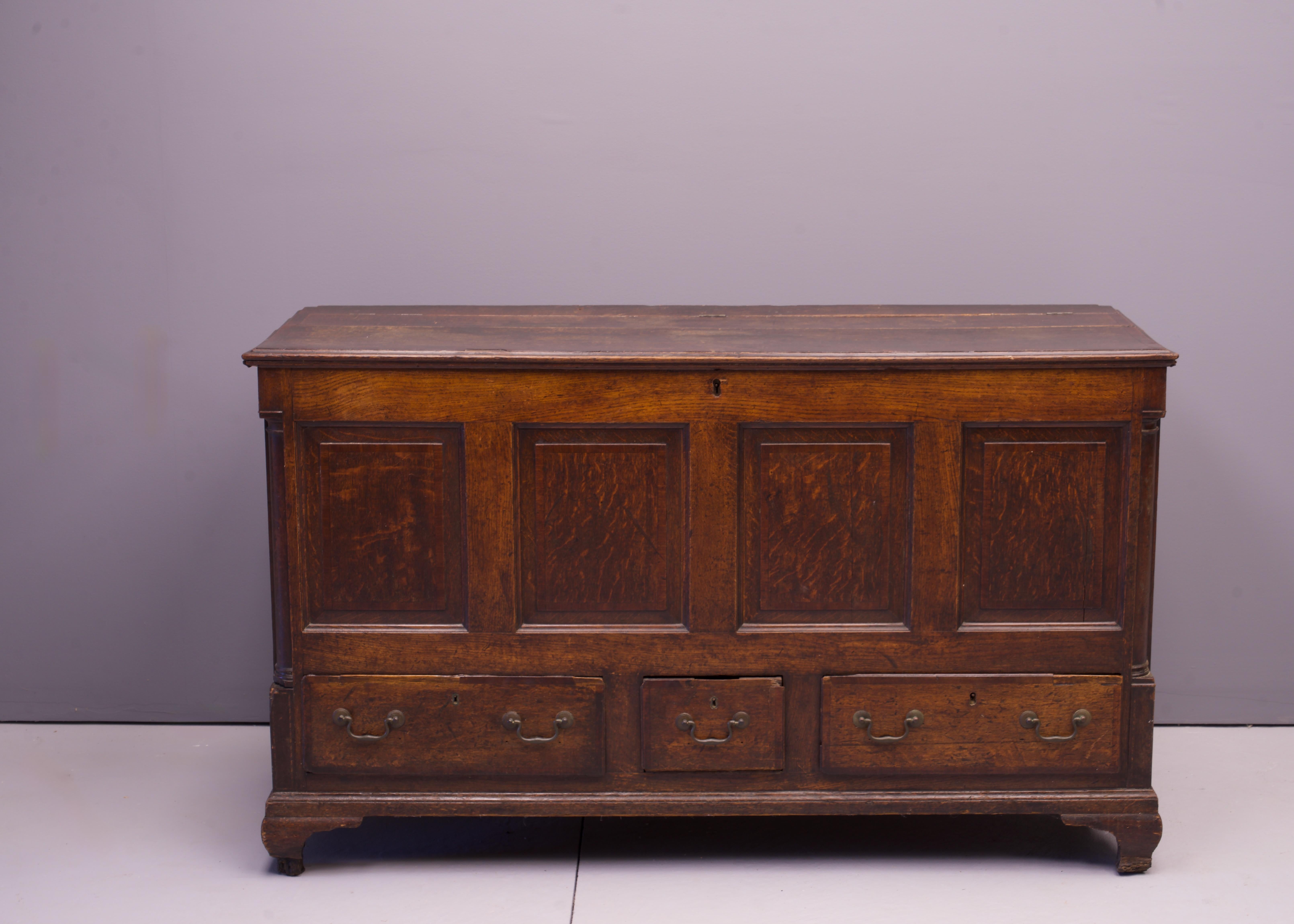 A 19th Century Lancashire Panelled Oak Hardwood Mule Trunk. Heavily worn, warped, and patinated. Mars and wear to all surfaces. Missing many pieces of carved decor, veneer, especially around the feet, top boards are warped. Many locks present but no
