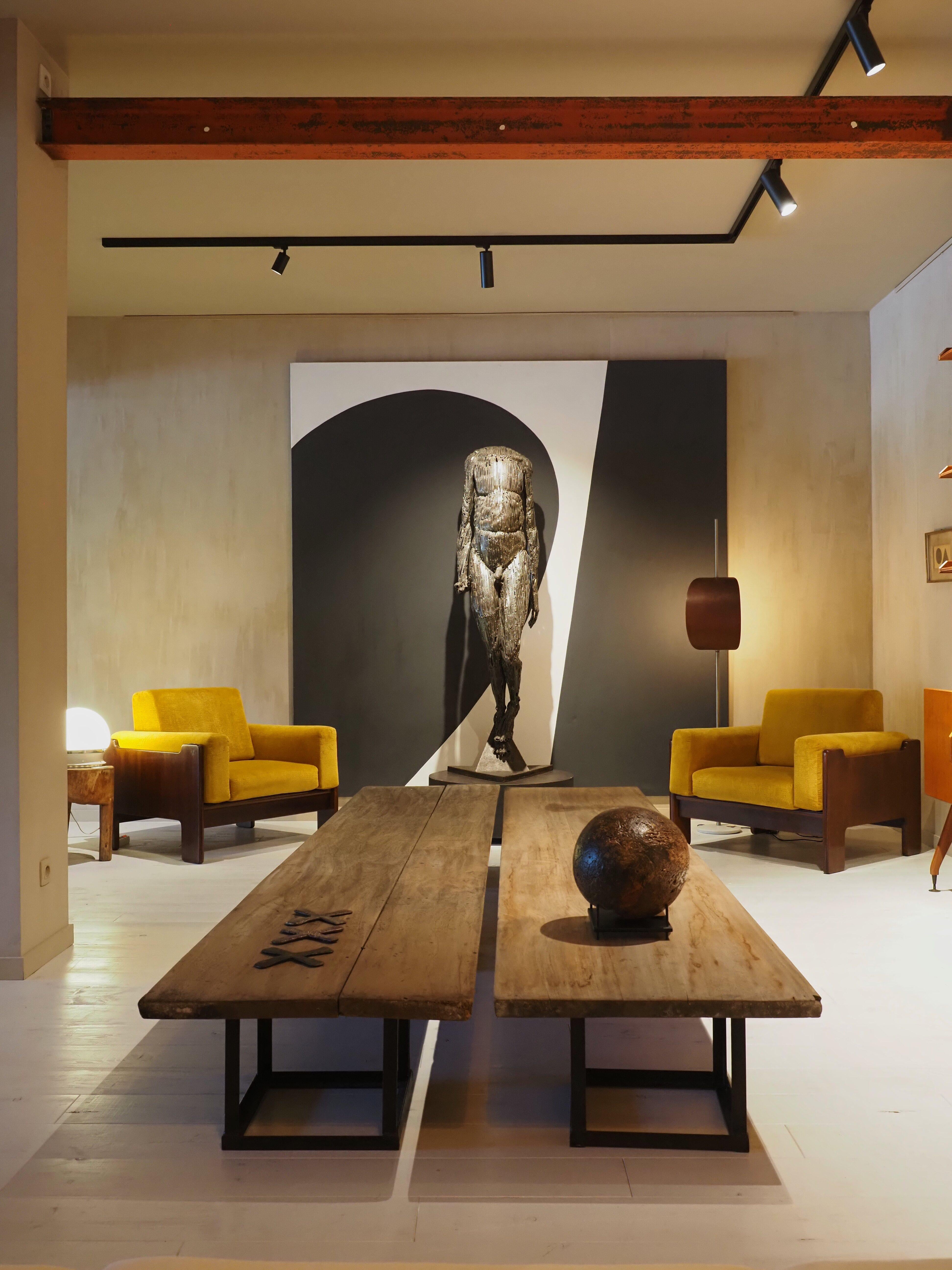 This rare set of two coffee tables immediately stands out for its impressive proportions and timeless character. Each table measures 336 cm in length, 65 cm in width, and 37 cm in height. The height can be easily adjusted, as the three iron bases