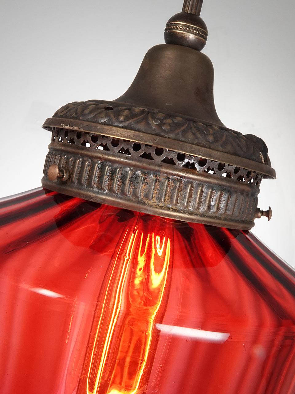 This was a very early oil or candle lantern that was rethought as an electric pendent. All the parts are original to the original fixture except for a new E26 socket. The 8 inch diameter globe on this example is a rare tapered and fluted Ruby Glass.