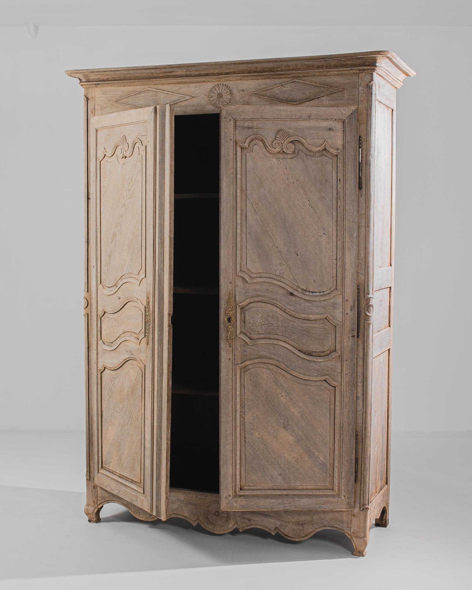 Transporting us to the refined interiors of 19th-century France, this bleached oak armoire stands as a testament to the exquisite craftsmanship and timeless elegance of the era. Crafted with meticulous attention to detail, this piece embodies the