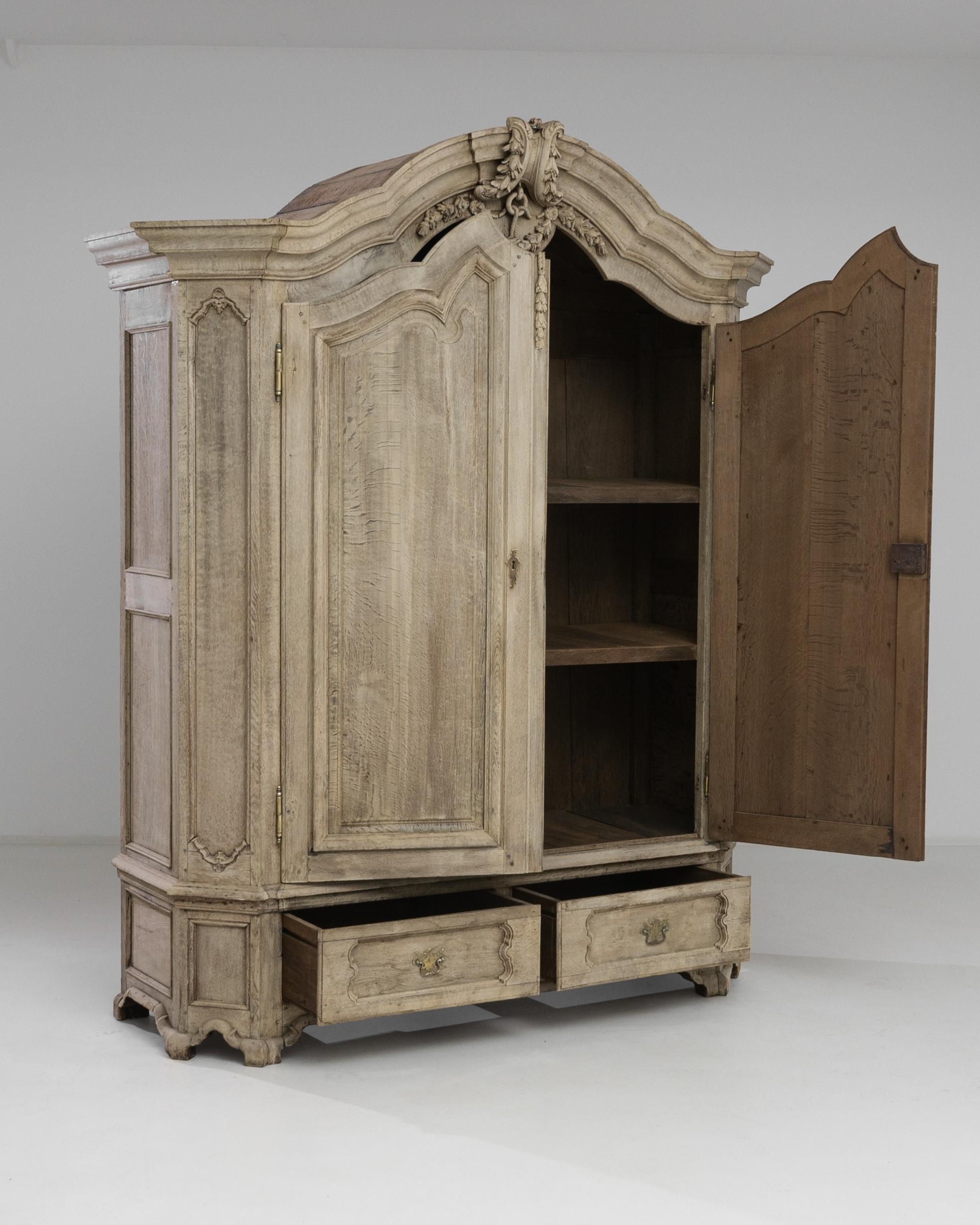 Immerse your space in the timeless elegance of the 1800s French Bleached Oak Cabinet, a masterpiece that transcends centuries with its refined design. The two main doors open to reveal two shelves inside, adorned with a dark finish, creating a