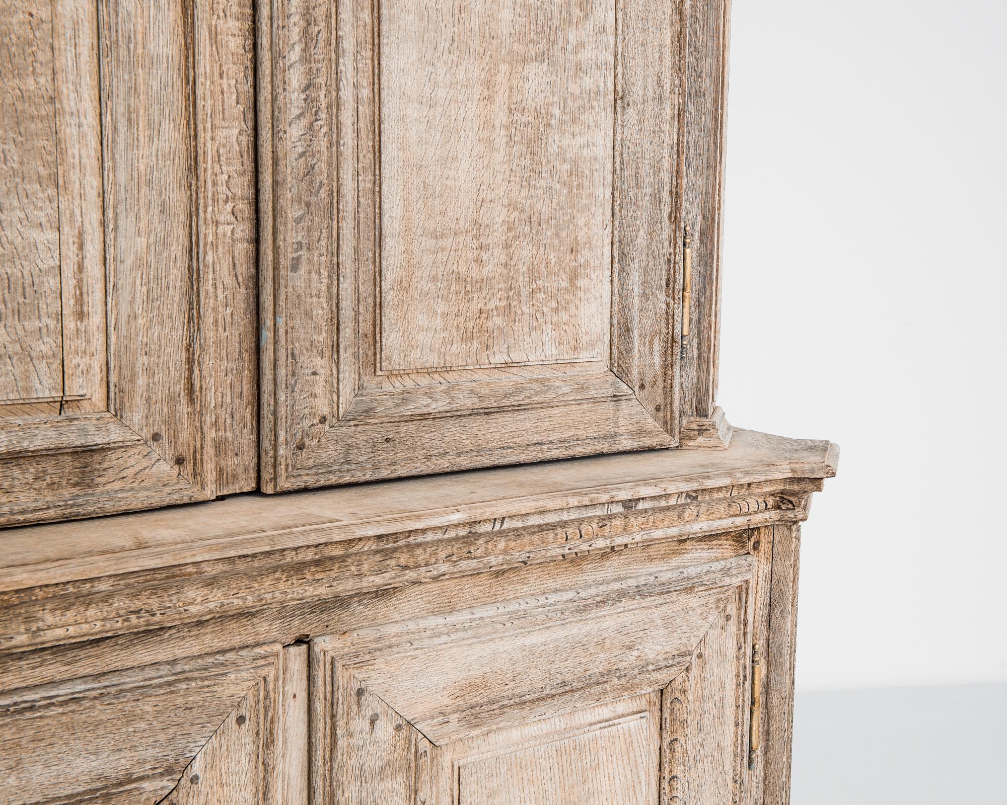 Der französische Schrank aus gebleichter Eiche, ein exquisites Stück, das klassisches Design mit sorgfältiger Handwerkskunst verbindet, lässt Sie in die zeitlose Eleganz der 1800er Jahre eintauchen. Mit seiner geschwungenen Platte und den gekrönten