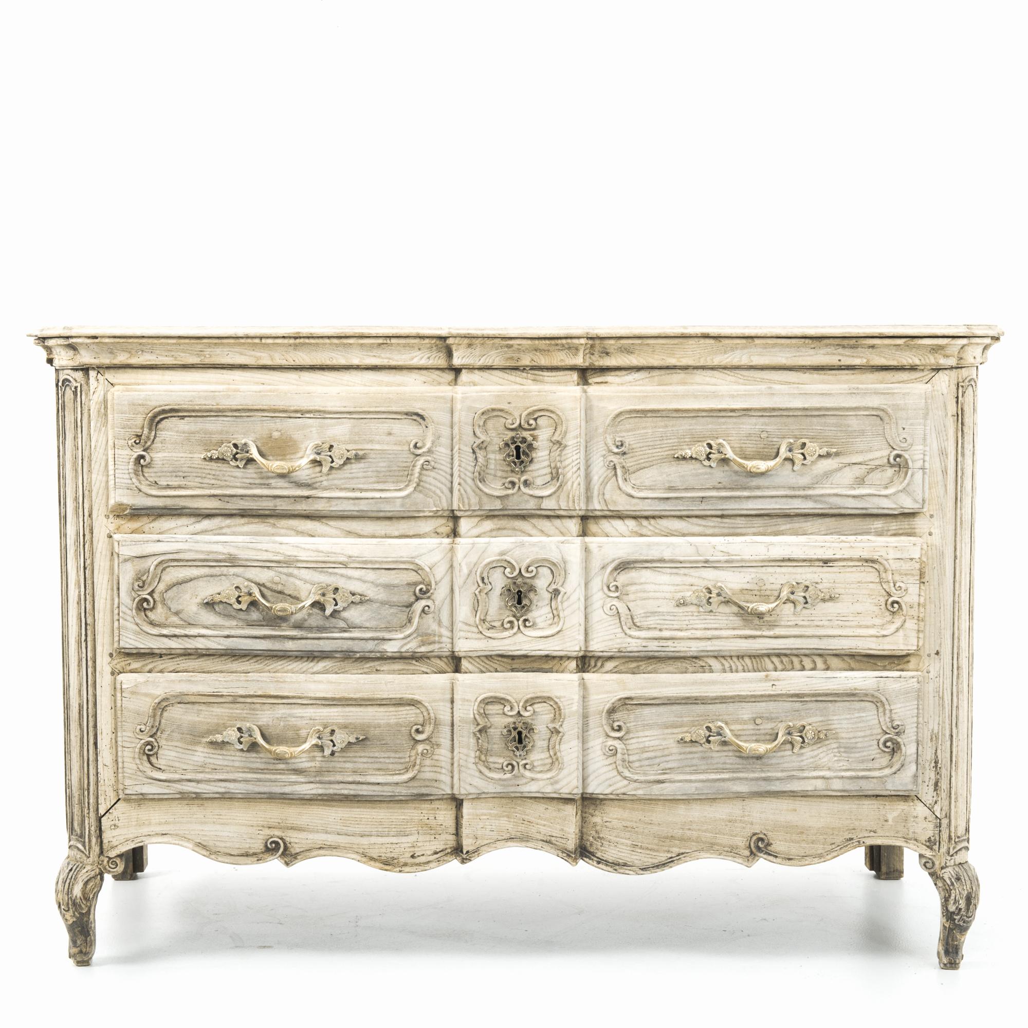 A three drawer oak chest from France, circa 1800. Distinctive period design is highlighted by the unique finish, the wood has been restored in our workshops to a light, natural color, complimenting the natural tones of the oak. A lively pattern of
