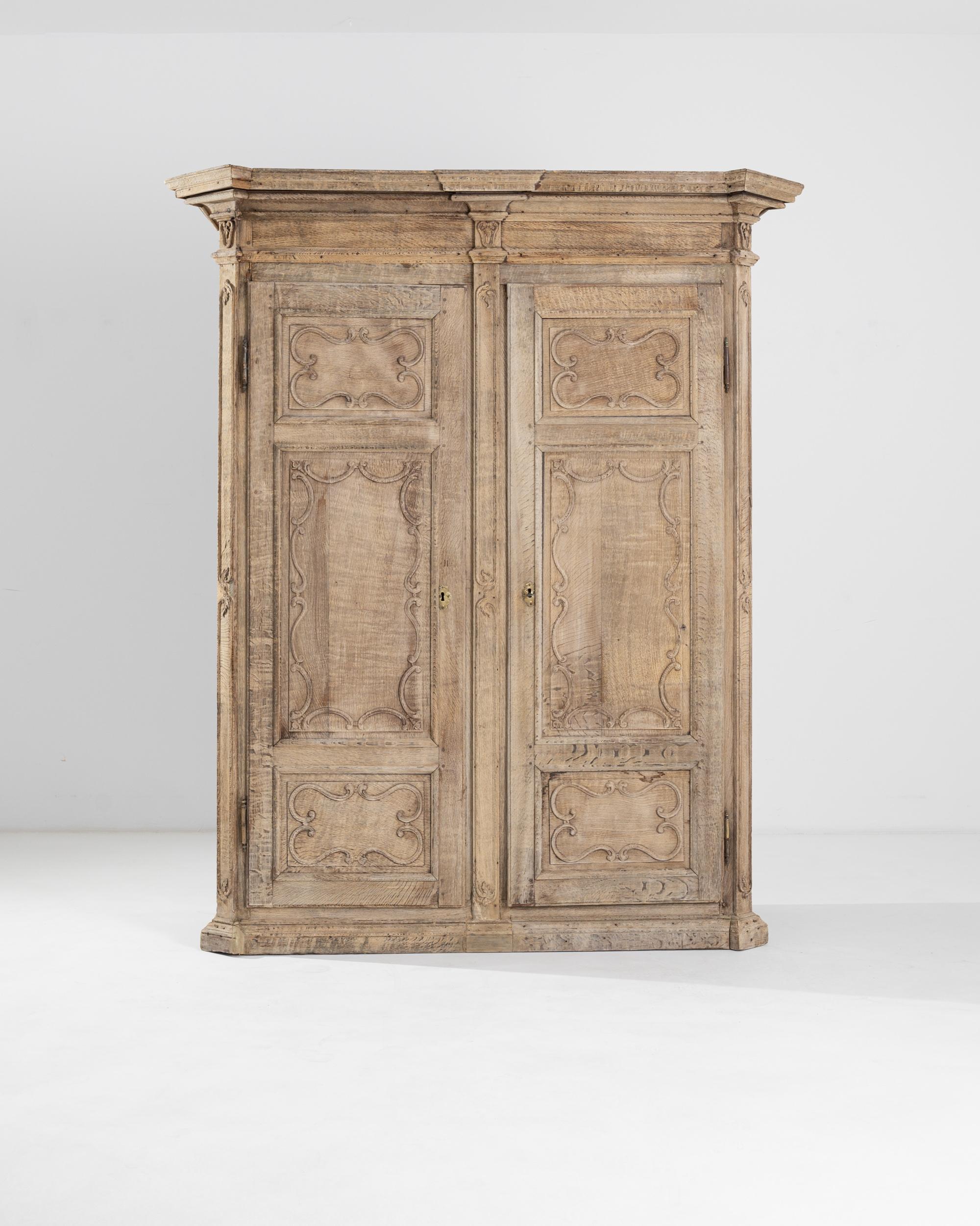 Crafted out of stout oak, this 19th-century French cabinet boasts a beautifully molded cornice with jutting corners crowning the top of the chest. Beveled elements and rectangular panels punctuate the flawless symmetry, smoothened by charming