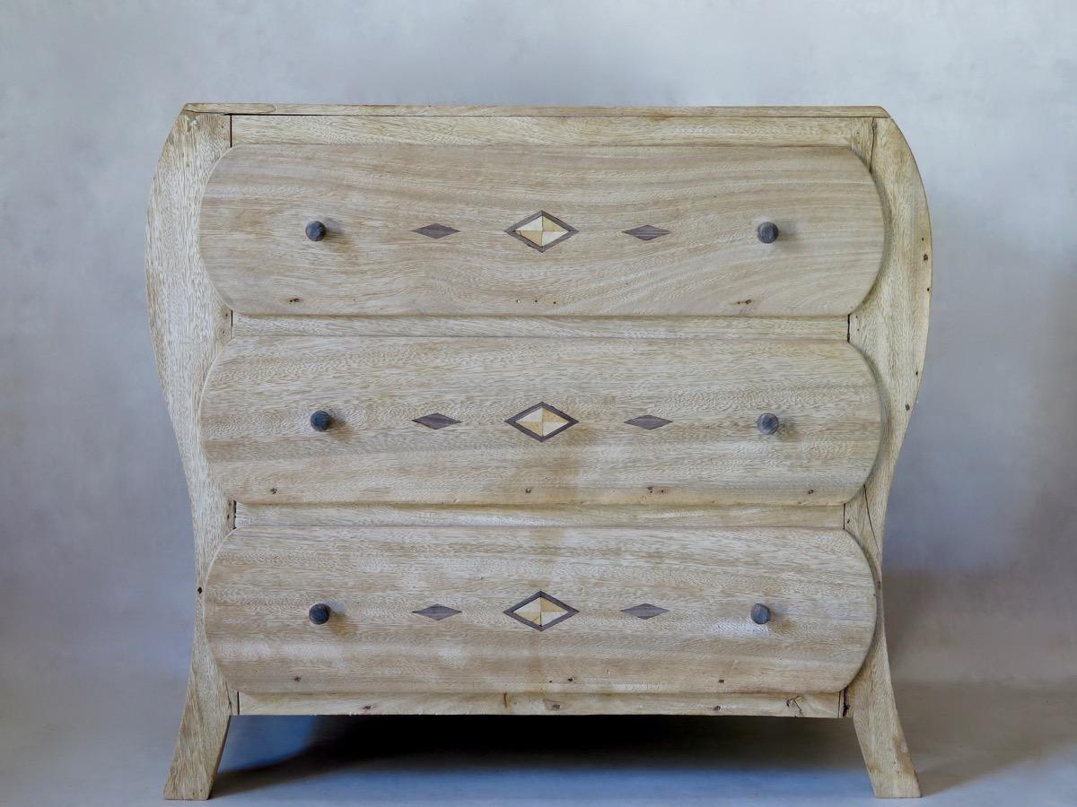 Very unusual chest of drawers with curved sides and inlays on the top and drawer fronts. An antique piece of furniture with a surprisingly modern feel.