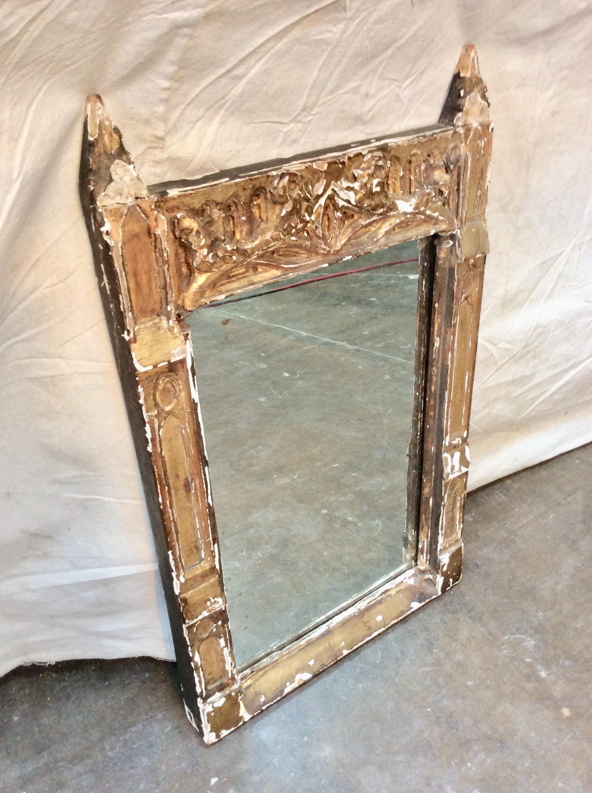 Found in the South of France, this beautiful carved and gilded French wall mirror features a decorative and ornate frame. The mirrored glass has some spotting and crazing which adds to the patina of the piece.

17.5
