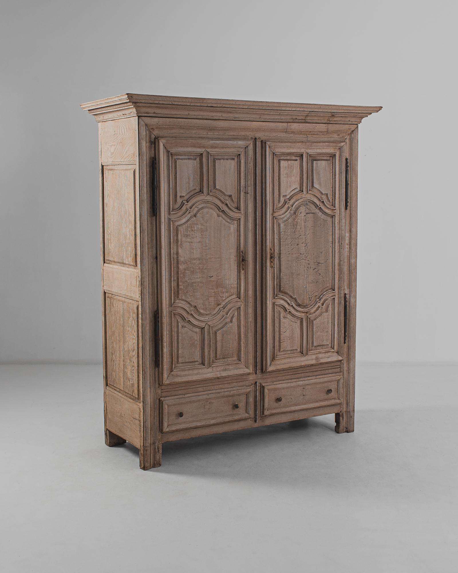 An oak armoire from France, circa 1800. Serpentine panelling on the cupboards doors gifts a baroque elegance to the wide cabinet. Original lock pieces add a decorative touch. The wood has been restored in out workshops to a natural finish, revealing