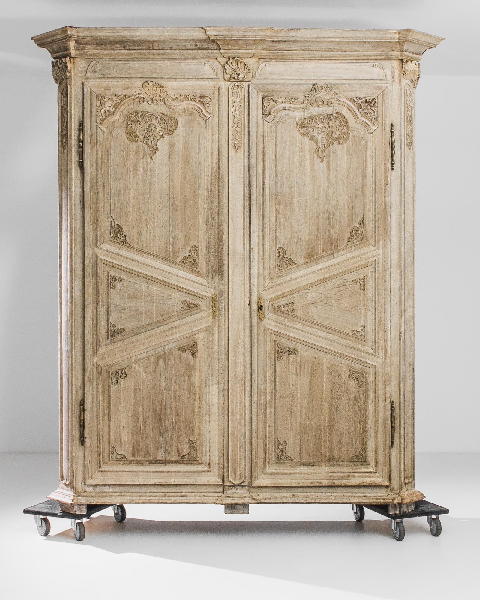 Carved detail and diagonal panelling give this oak armoire a unique appeal. Made in France circa 1800, the X-shaped panels of the doors create an eye-catching accent. Baroque flourishes decorate the inner corners of the panels and upper cornices,