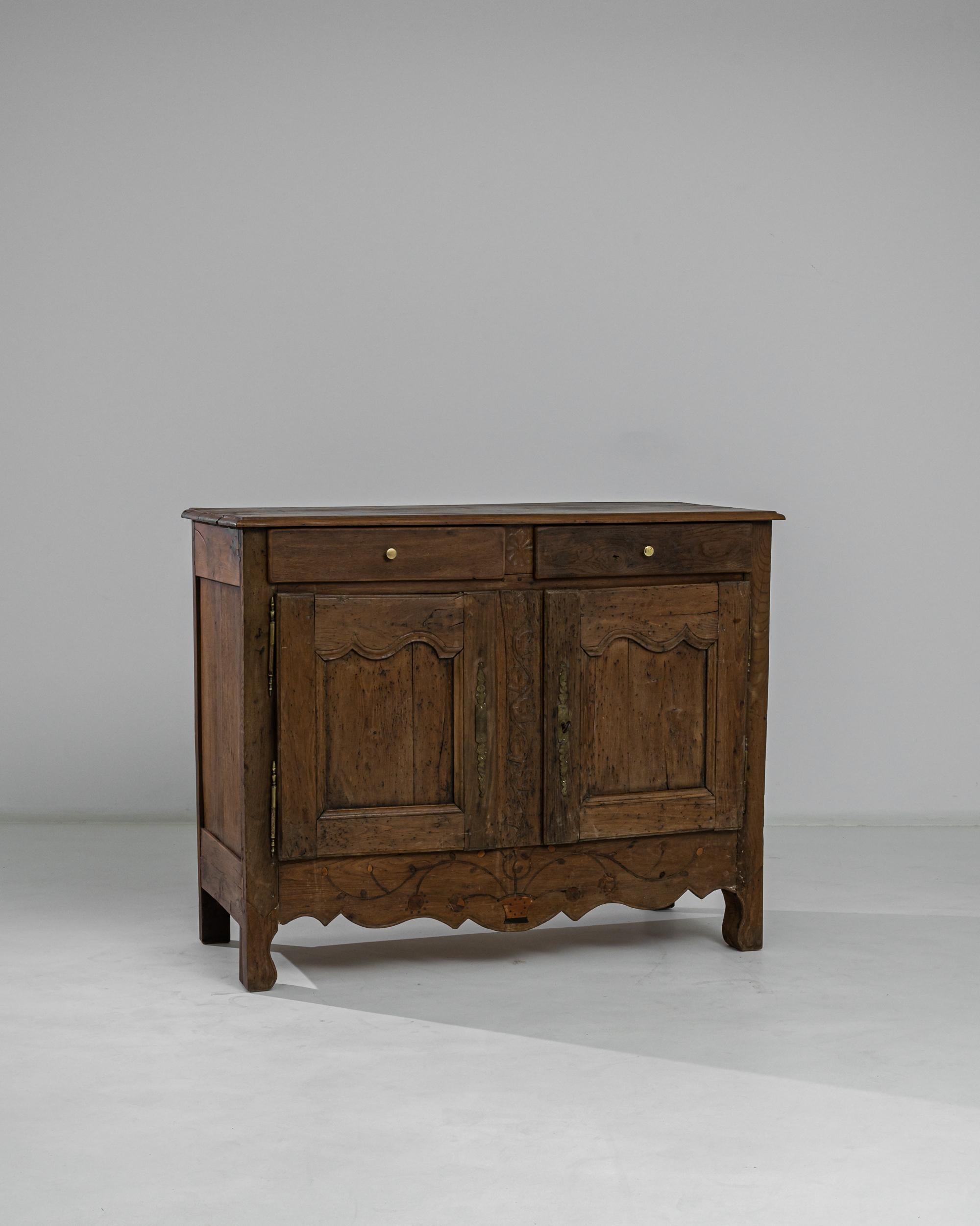 A French wooden buffet from the 1880s. Lively floral details carefully carved into this buffet’s rich wooden patina emit an almost childlike playfulness. A latticework of nuanced wood tones and inscribed metal details bring a dignified balance to
