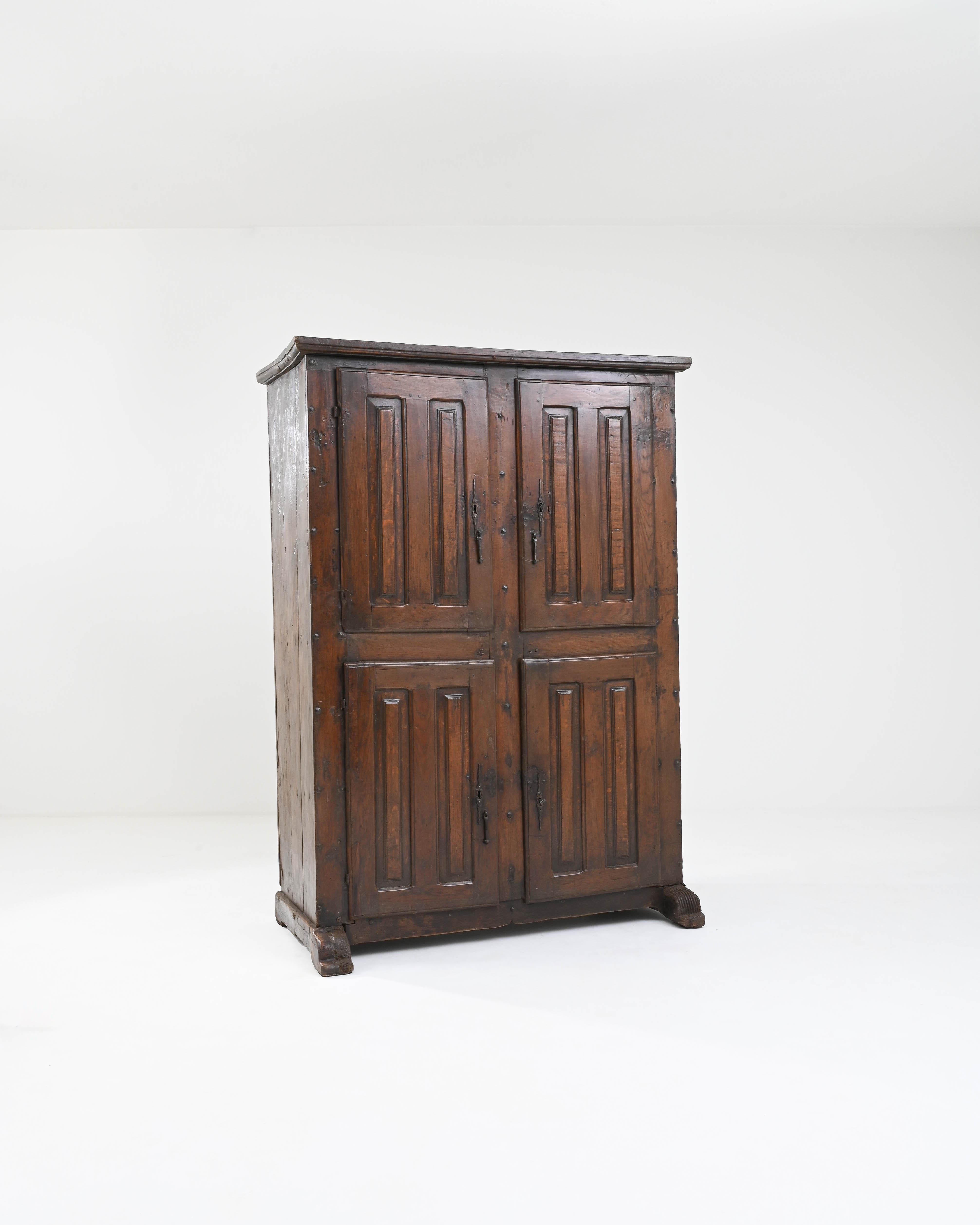 A handsome original patina gives this antique cabinet a unique character. Built in France circa 1800, the dark finish of the wood has mellowed to a rich, lacquered polish, revealing warm notes of cherry red and amber beneath. The silhouette has a