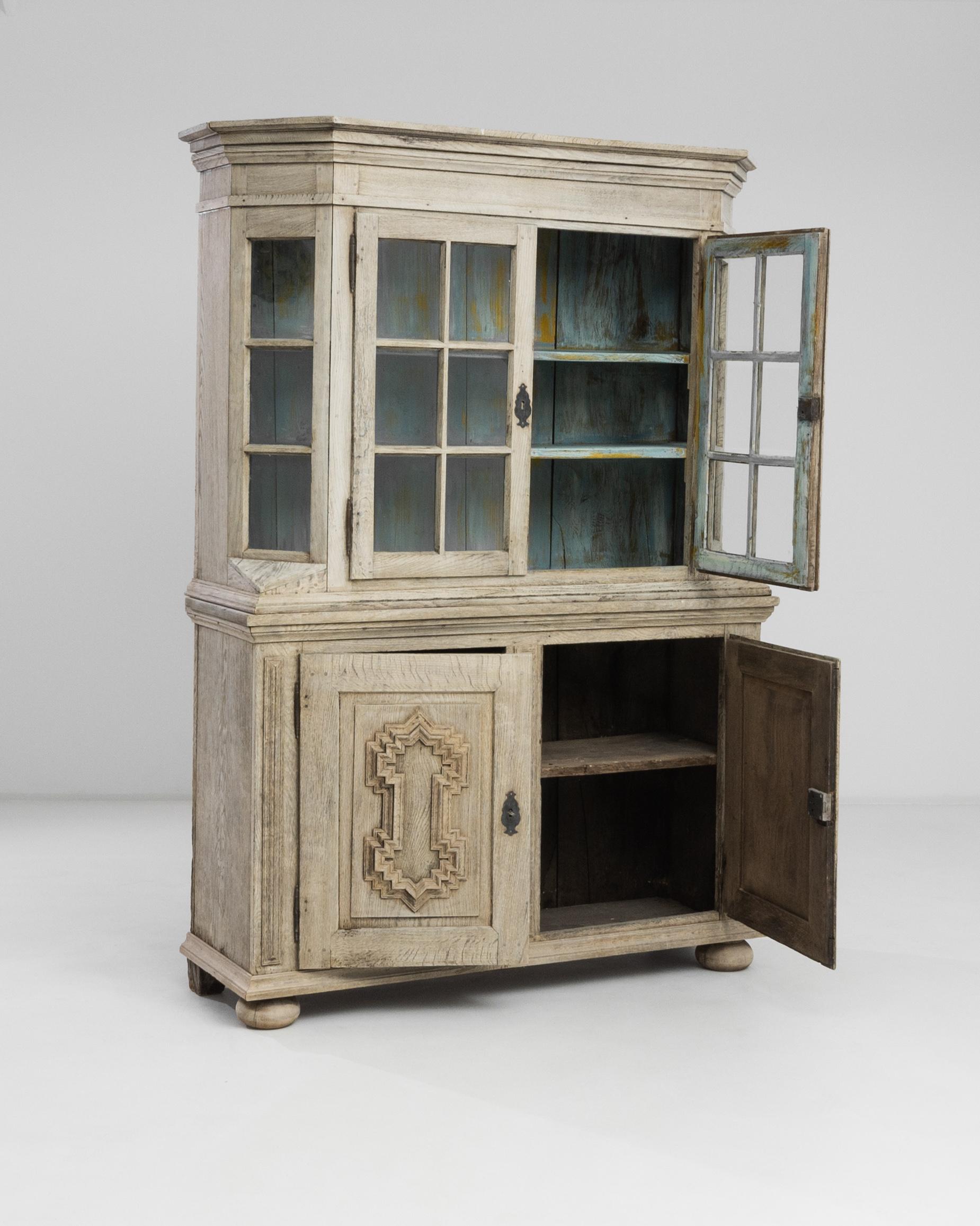 The 1800s German Bleached Oak Vitrine presents an exquisite blend of rustic charm and timeless elegance. Crafted during a period where attention to detail was paramount, this vitrine showcases a weathered patina that whispers stories of its past