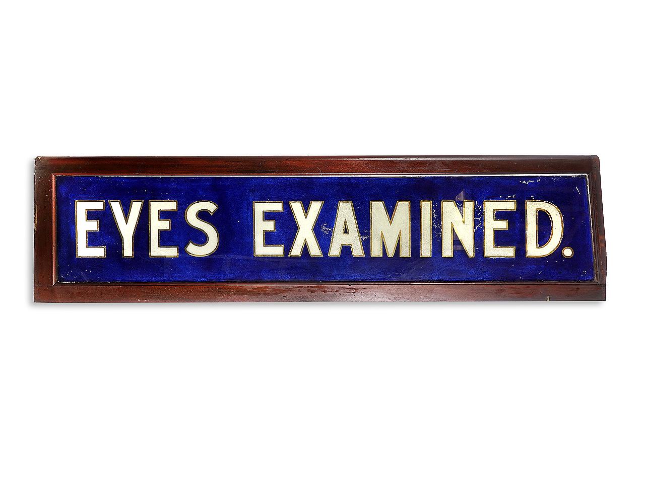 This is an original cobalt blue, gold leaf and white reverse painted glass sign. It reads eyes examined. It still has the rough frame from the store around it. It came out of a New England estate where it was in storage for all these years. The