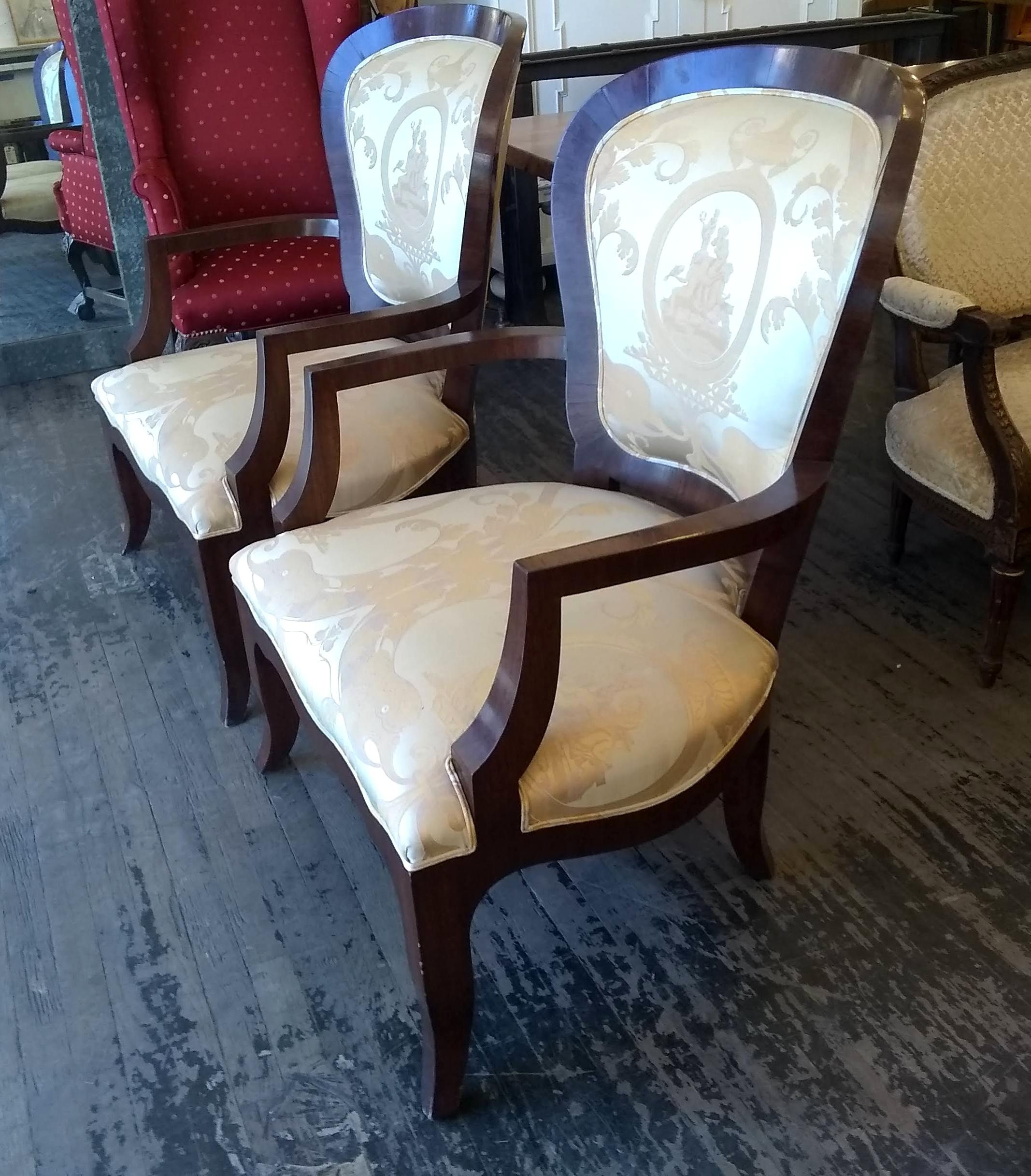 1800s silk armchairs with decorative detailing on the fabric and a dark mahogany wood tone frame. There is minor cracking on the veneer. Priced as a pair. Please note, this item is located in our Los Angeles location.