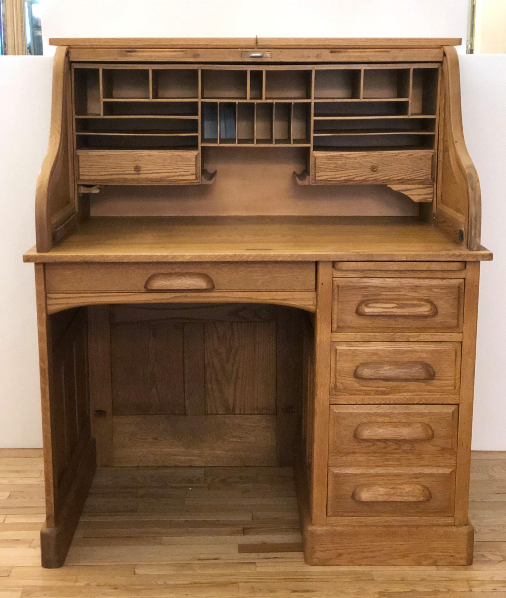 Late 1800s antique five drawer roll top desk with raised panels. Solid oak. Comes with key. Minor staining. This can be seen at our 333 West 52nd St location in the Theater District West of Manhattan.