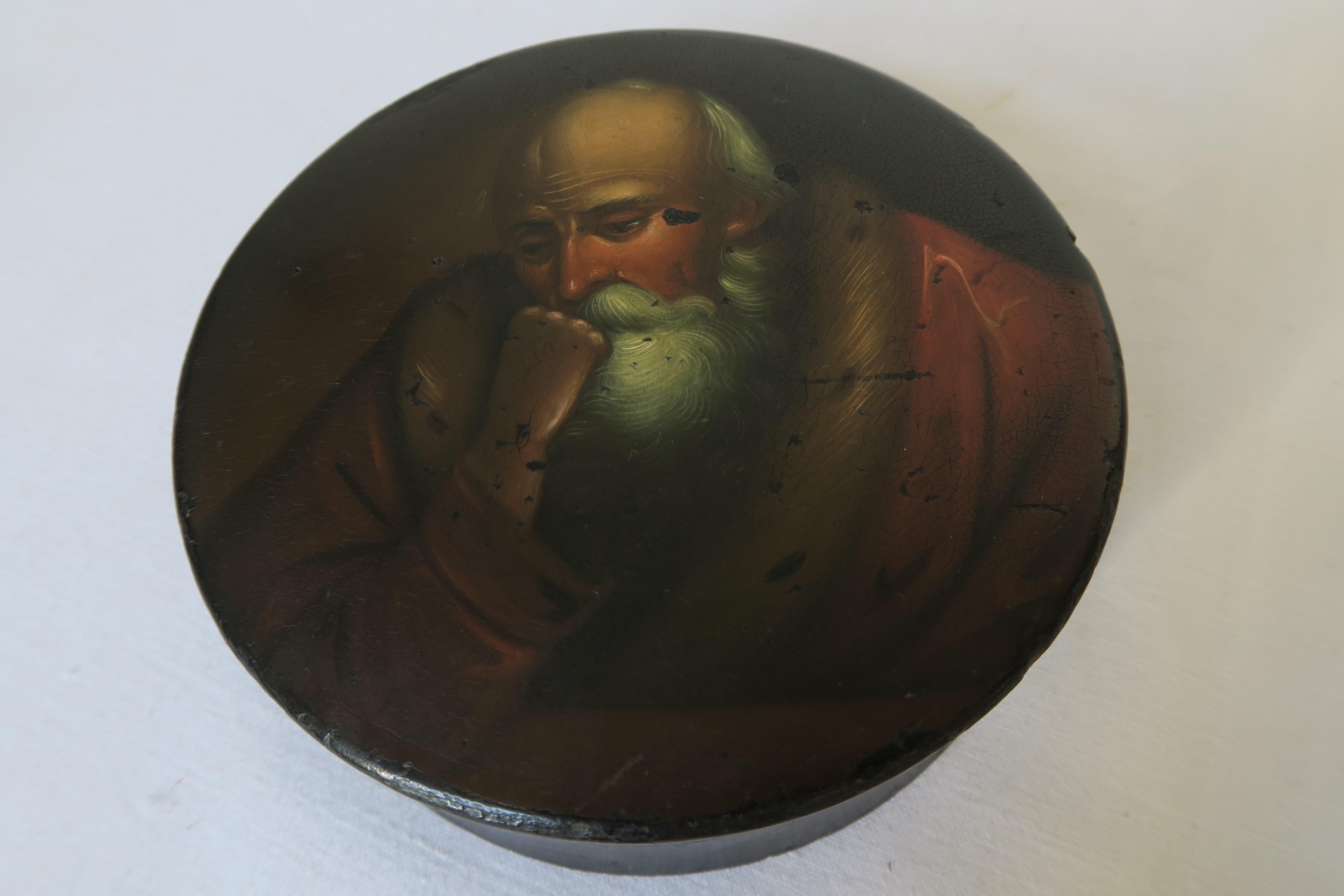 In this ad you get the chance to buy a beautiful hand-painted Russian lacquer box from the 1800s. It is cylindrical in shape, slightly curving inwards where box and lid meet. Hand-painted on the lid is the portrait of a philosopher who looks deeply
