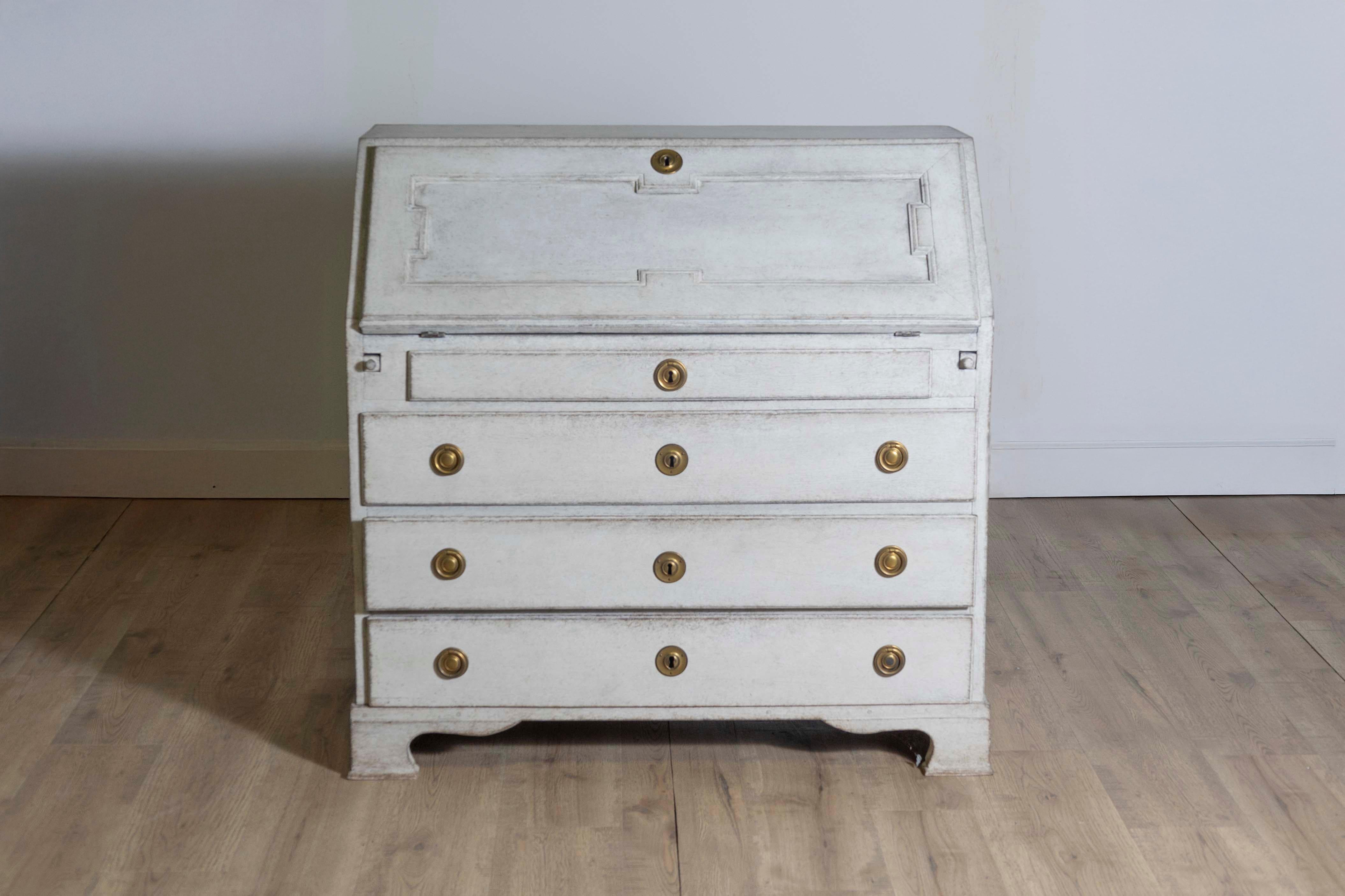 A Scandinavian slant-front secretary from circa 1800 with carved panel, four drawers, light gray / cream painted finish and carved bracket feet. Steeped in history and elegance, this Scandinavian slant-front secretary from circa 1800 is a testament