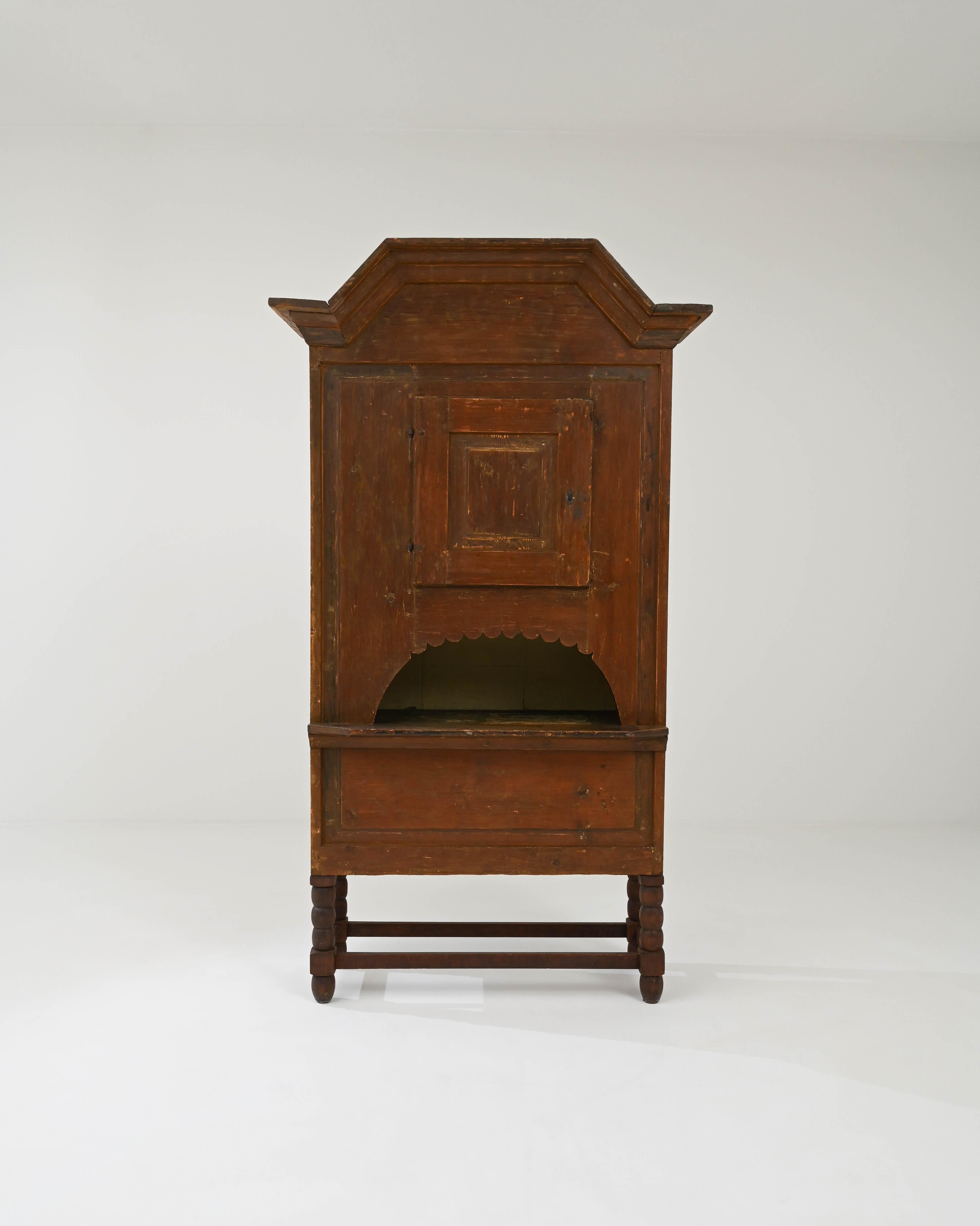 A wooden cabinet created in 1800s Sweden. Quiet and mysterious, this wooden cabinet communicates a sense of rich history and old-world artisanry. Carefully lathed and joined legs undergird the body of the cabinet, which features a curious little