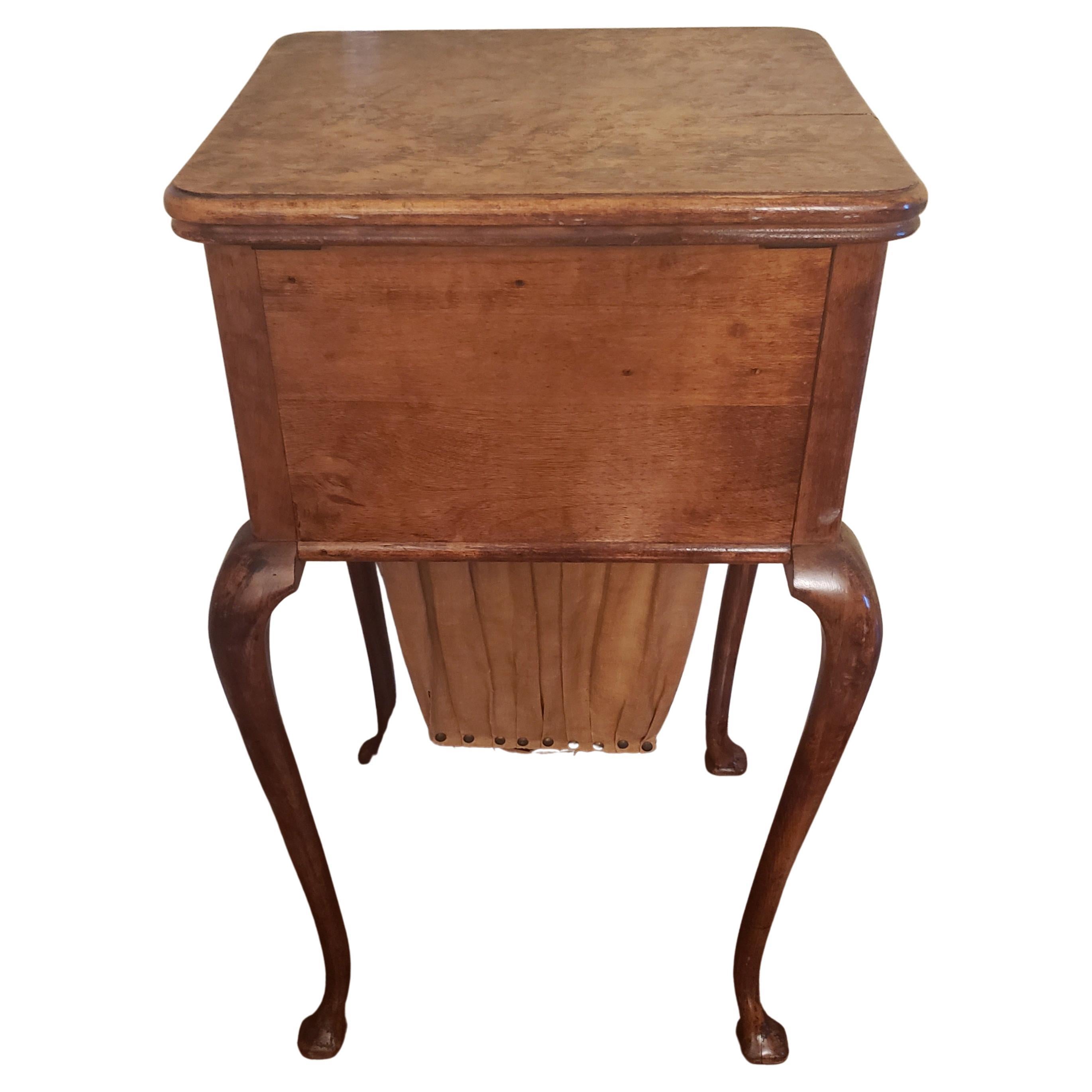 This a vintage English sewing table with its original scrap bag and finish. This table comes with a deep dovetail right side drawer. Top opens to reveal a storage area divided with a compartmental tray . Tray is removable. Open top also reveals a