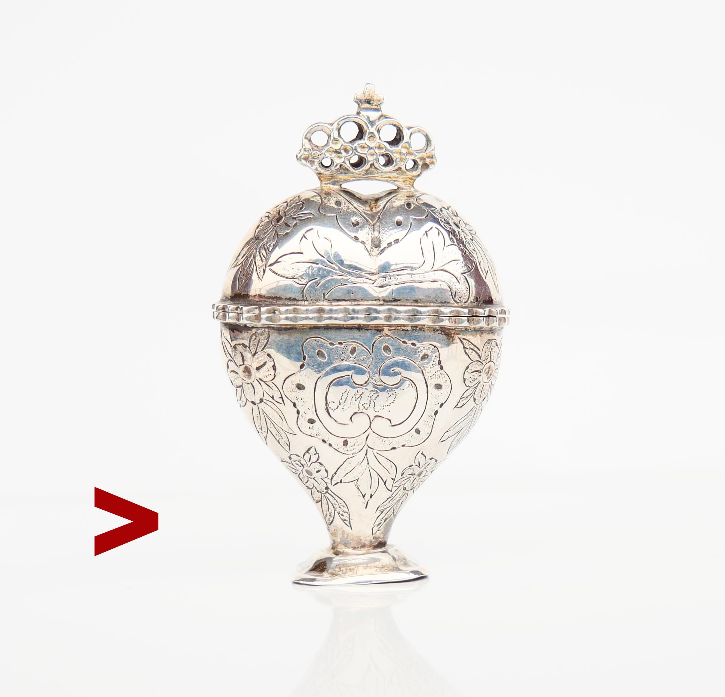 Alte dänische Eitelkeits- oder Pillendose mit Scharnier aus dem frühen 19. Jahrhundert in der ungewöhnlichen Form eines Herzens mit Krone auf der Oberseite. Handgehämmerte und gravierte Blumenornamente auf beiden Seiten. Vorderseite mit