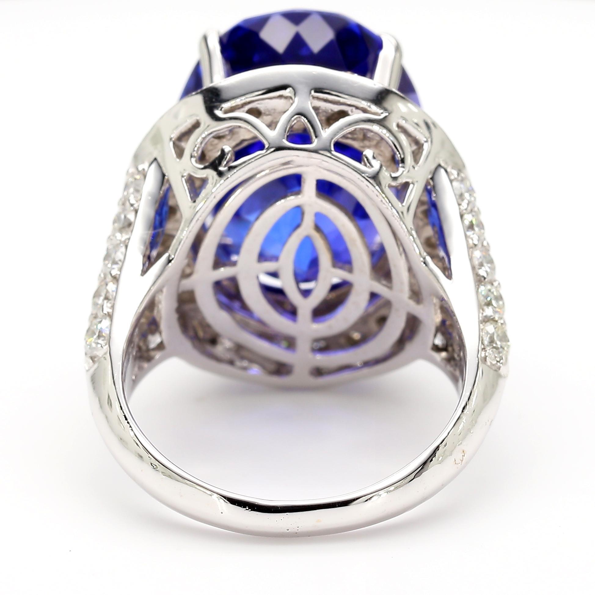 Cette bague de cocktail est ornée d'une tanzanite de 18,06 carats de qualité AAAA de taille ovale. Encadrée de 2,5 carats de diamants éblouissants et sertie dans un sculptural or blanc 18 carats avec une tige filigranée fendue, cette bague est