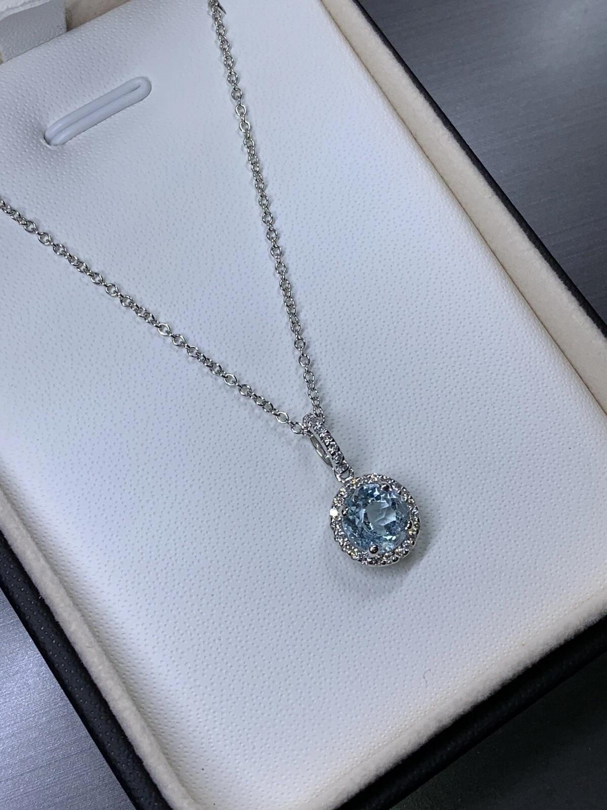 Améliorez votre collection de bijoux avec ce collier pendentif solitaire en aigue-marine et diamant de 1,80ct. Réalisé en or blanc 18 ct, ce pendentif présente une aigue-marine ronde en serti solitaire, accompagnée d'un diamant unique. Le pendentif
