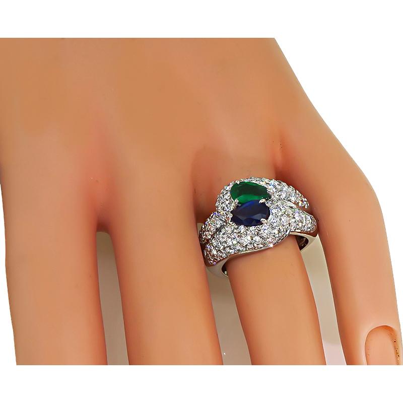This is a gorgeous 18k white gold ring. The ring is centered with lovely pear shape sapphire and emerald that weighs approximately 0.90ct and 0.75ct respectively. The colored stones are accentuated by sparkling round cut diamonds that weigh