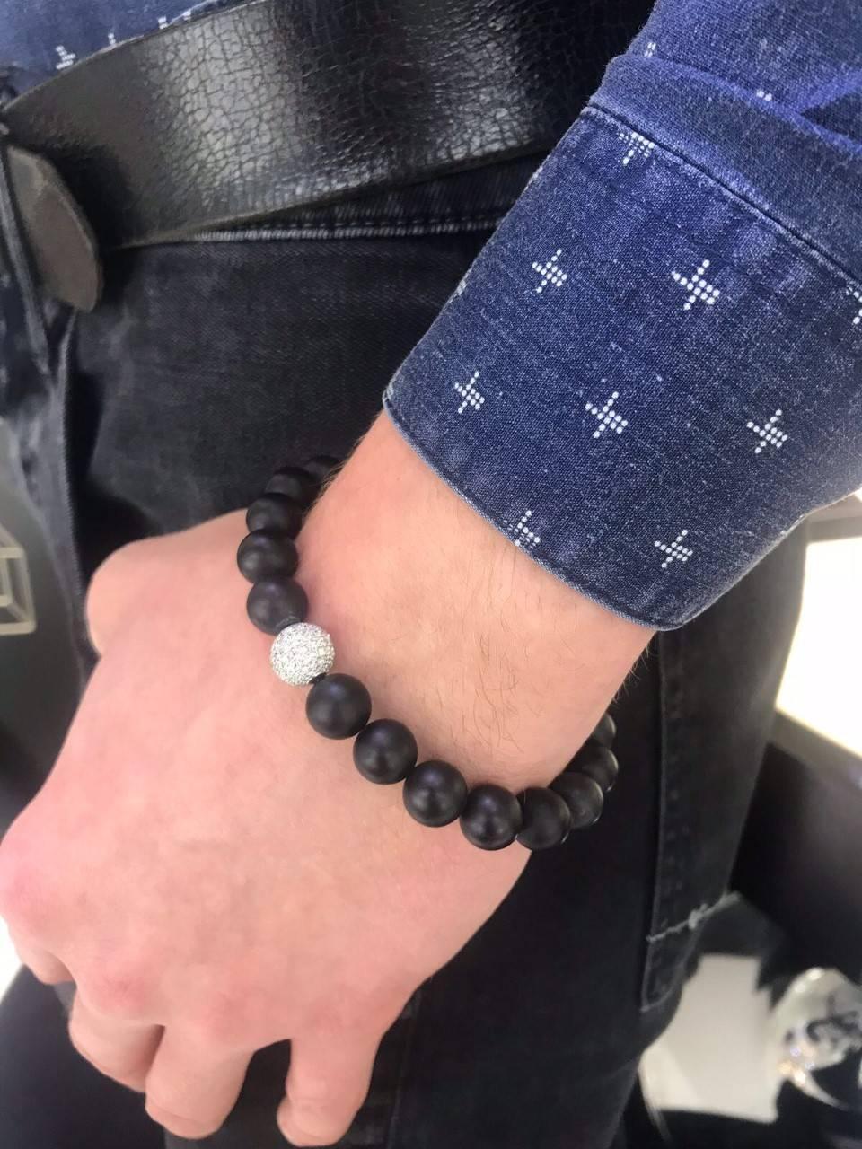 black bead bracelet with one white bead