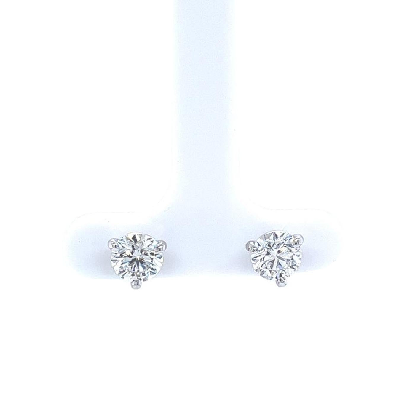These Diamond stud earrings feature two round brilliant cut diamonds, totaling 1.80ctw. They are mounted in 3-prong martini mountings. The first diamond weighs 0.90ct and is graded by the GIA as Very Good cut, E color, and SI1 clarity with GIA