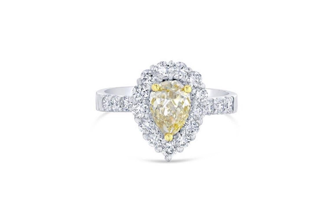 The center fancy colored diamond is a pear cut natural diamond weighing 1.06 carats. 
The center diamond has a clarity of VS2 and the color is brownish-yellow. 
It is surrounded by 19 round cut diamonds weighing 0.75 carats. The white diamonds have