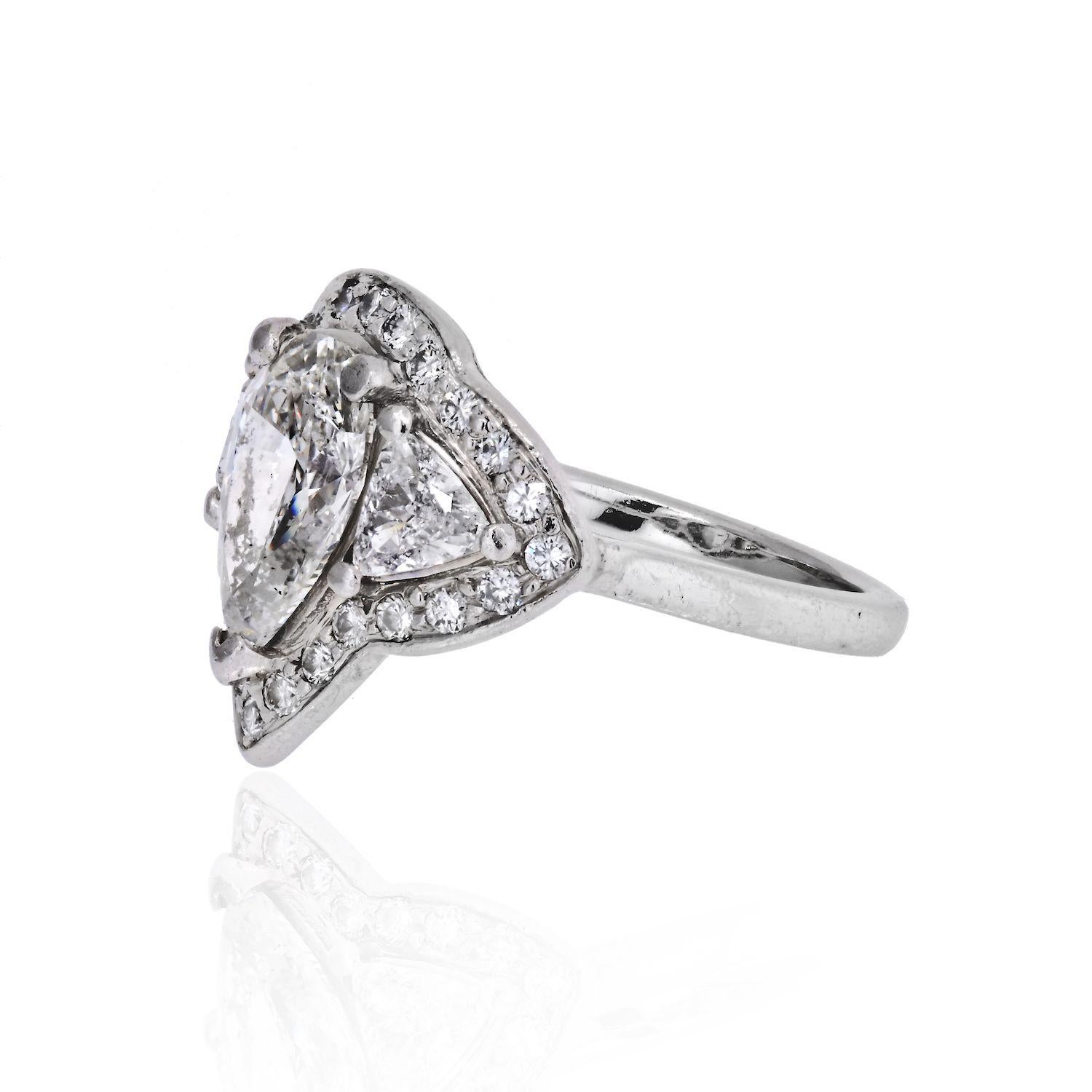 Always be on her mind when you propose with this Pear Shape Three Stone Diamond Engagement Ring. This features a Pear Cut center stone on a Halo 3 Stone Trilliants and a row micro pave halo. This unique designed ring will really look amazing on your