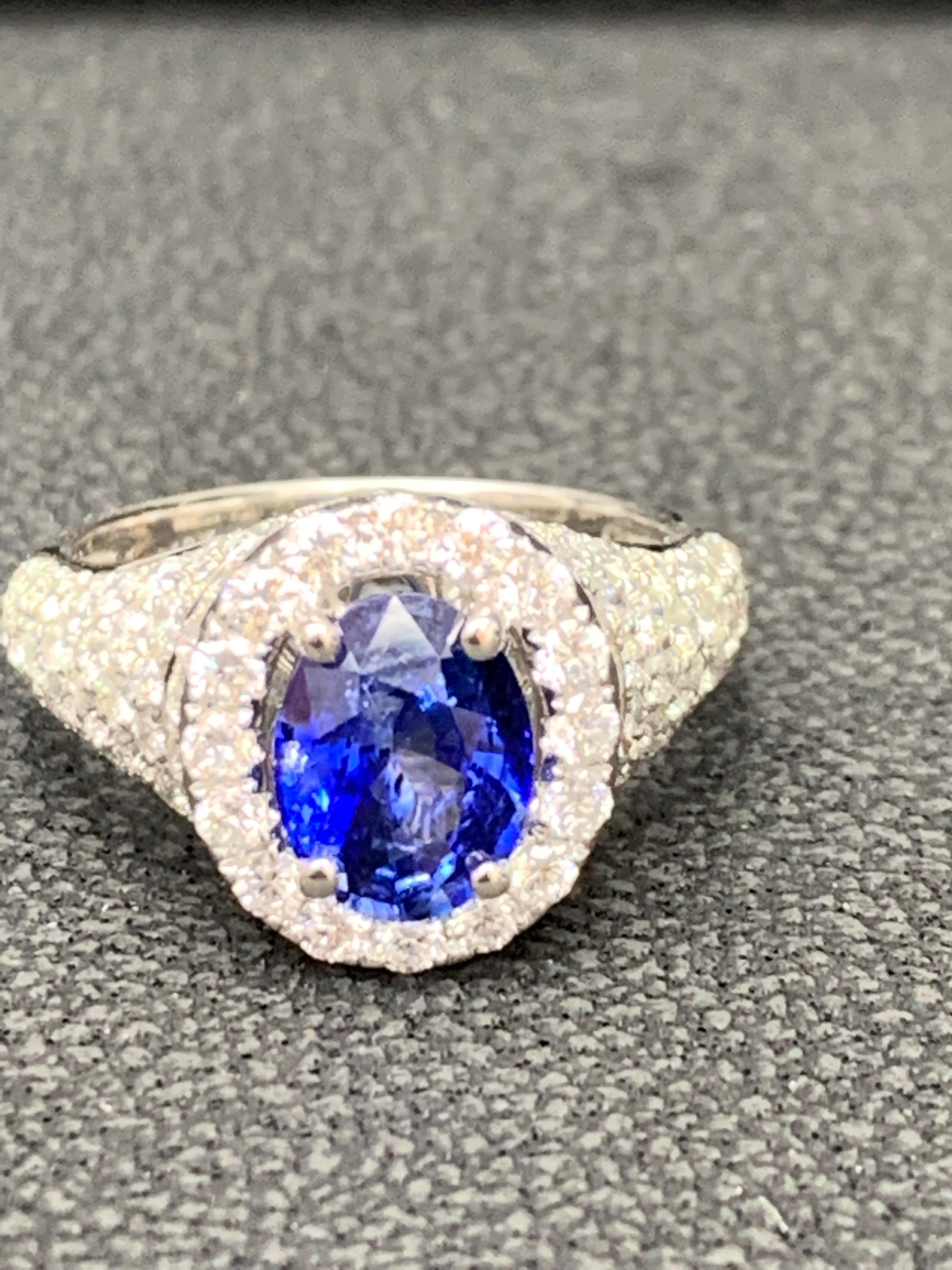 A uniquely-designed ring showcasing a 1.81 Carat Oval Cut Blue Sapphire. Surrounding the center stone are brilliant-cut round diamonds in an 18 karat white gold mounting. 112 diamonds weigh 1.77 carat in total.