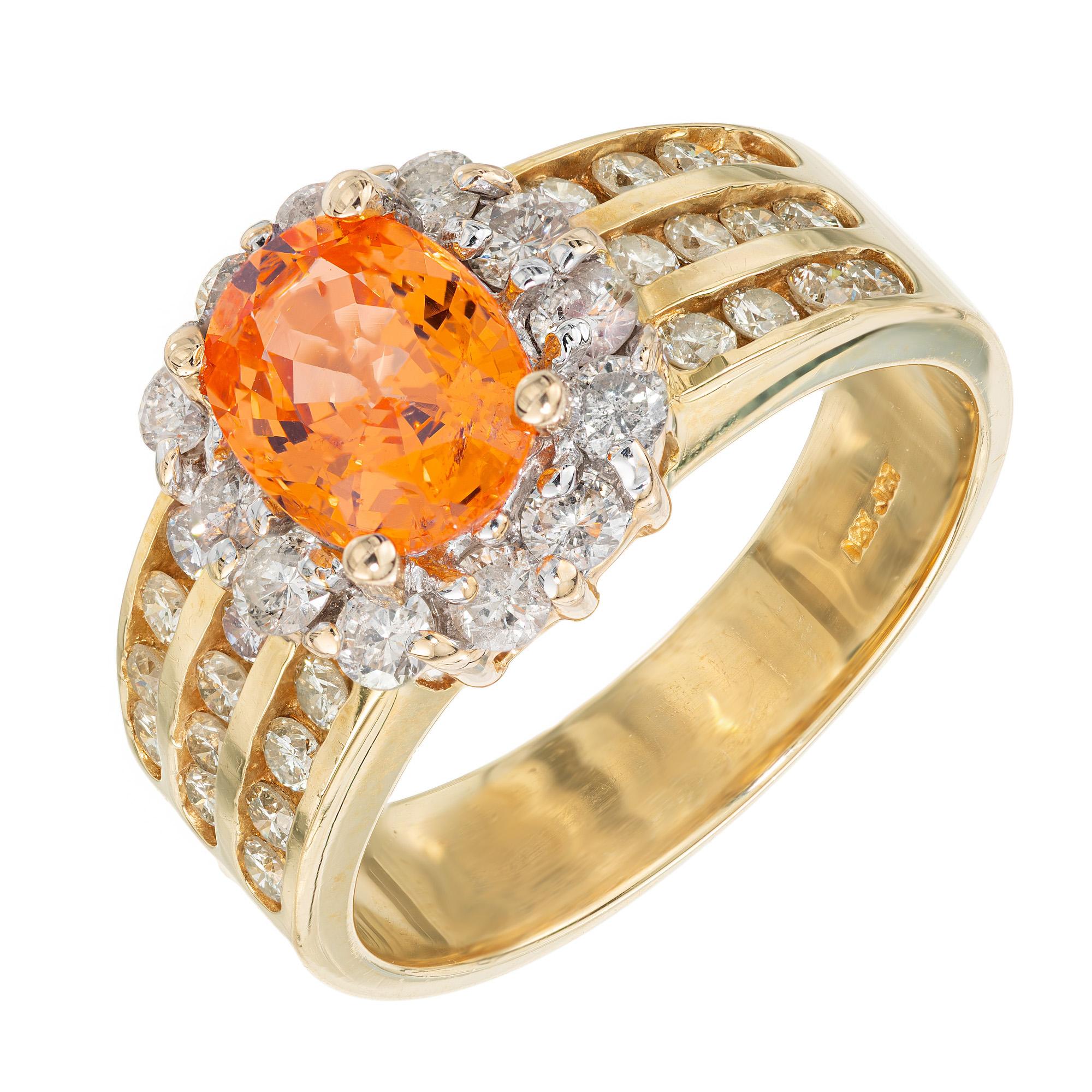 Estate bright orange Spessartite Garnet and diamond ring. Mounted in the center of this setting is a 1.81ct fiery orange oval garnet, which is elegantly complemented by the sparkling halo of round full cut diamonds. Both sides of the 14k yellow gold