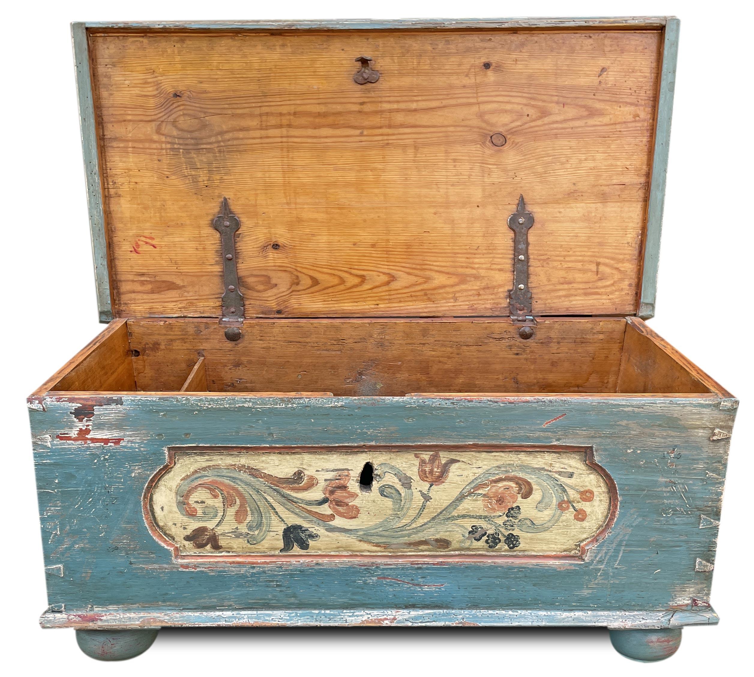 A small Tyrolean gem: blue chest with floral decorations

Small Tyrolean chest painted in blue.
On the front there is a generous box, with an ivory-colored background, containing elegant ramages and flowers.
Monochromatic floral decorations are also