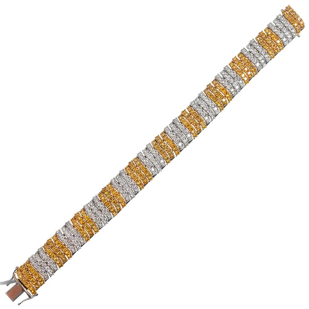 Candy stripes of intense yellow and brilliant white diamonds are set in 18 karat white and yellow gold. Draped across the wrist, the piece has a lovely and luxurious hand. In total the piece is set with 224 intense yellow diamonds that weigh 9.34