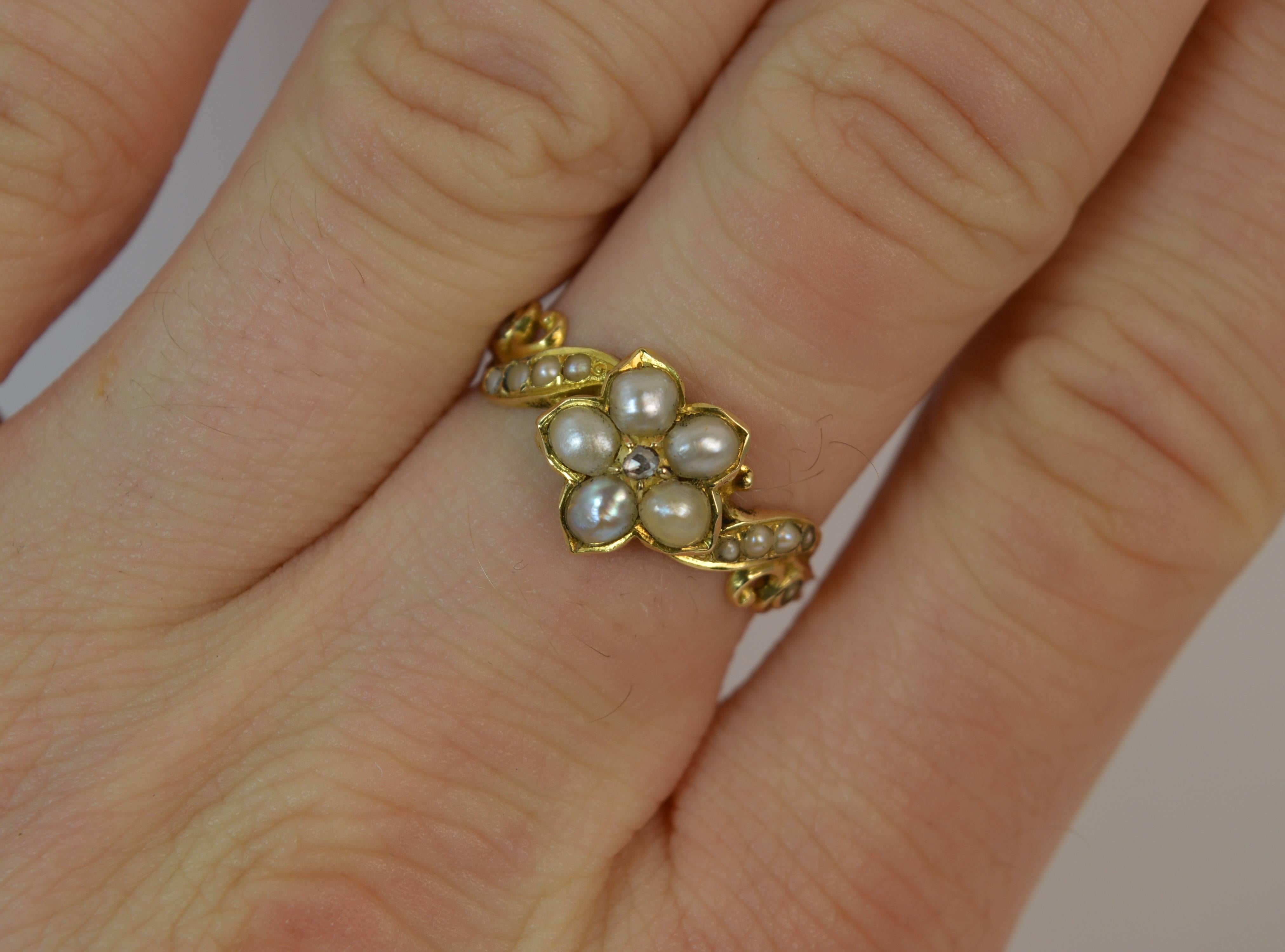 
A true Georgian period daisy cluster mourning ring. Solid 18 carat yellow gold example.

​Designed with a tiny rose cut diamond chip to centre with five pearl surround. 10mm x 10mm head. A further five seed pearls set to each shoulder.

​Engraved