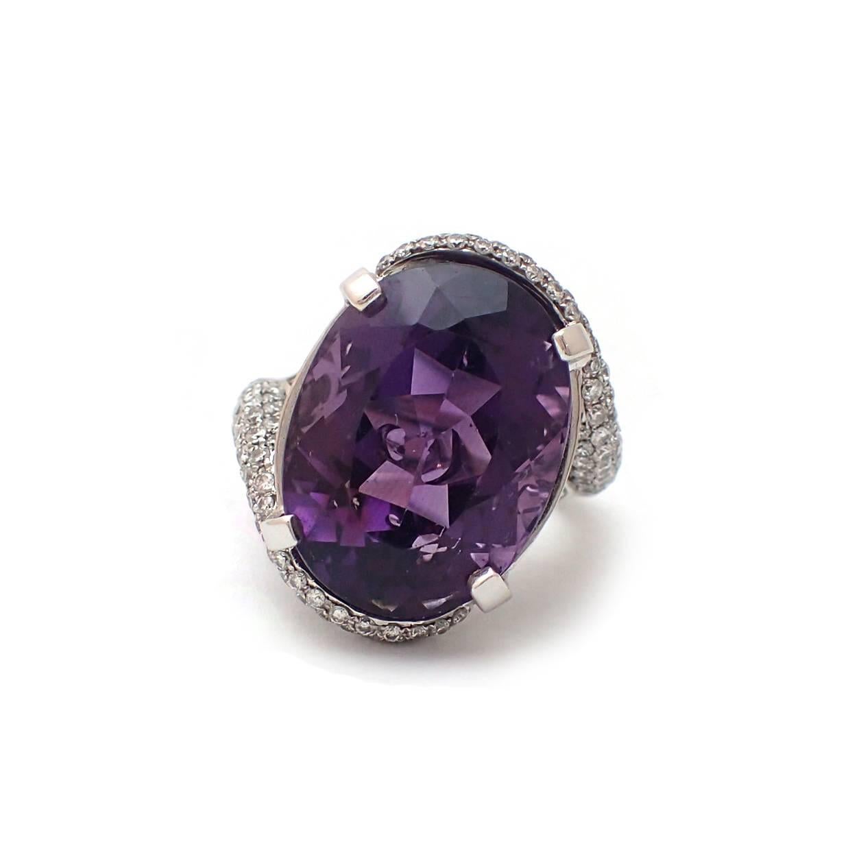 Make a statement with this ample 18.13ct oval Amethyst.  Showing off the stone is 1.2ct of diamonds in an 18k white gold swirl setting.  