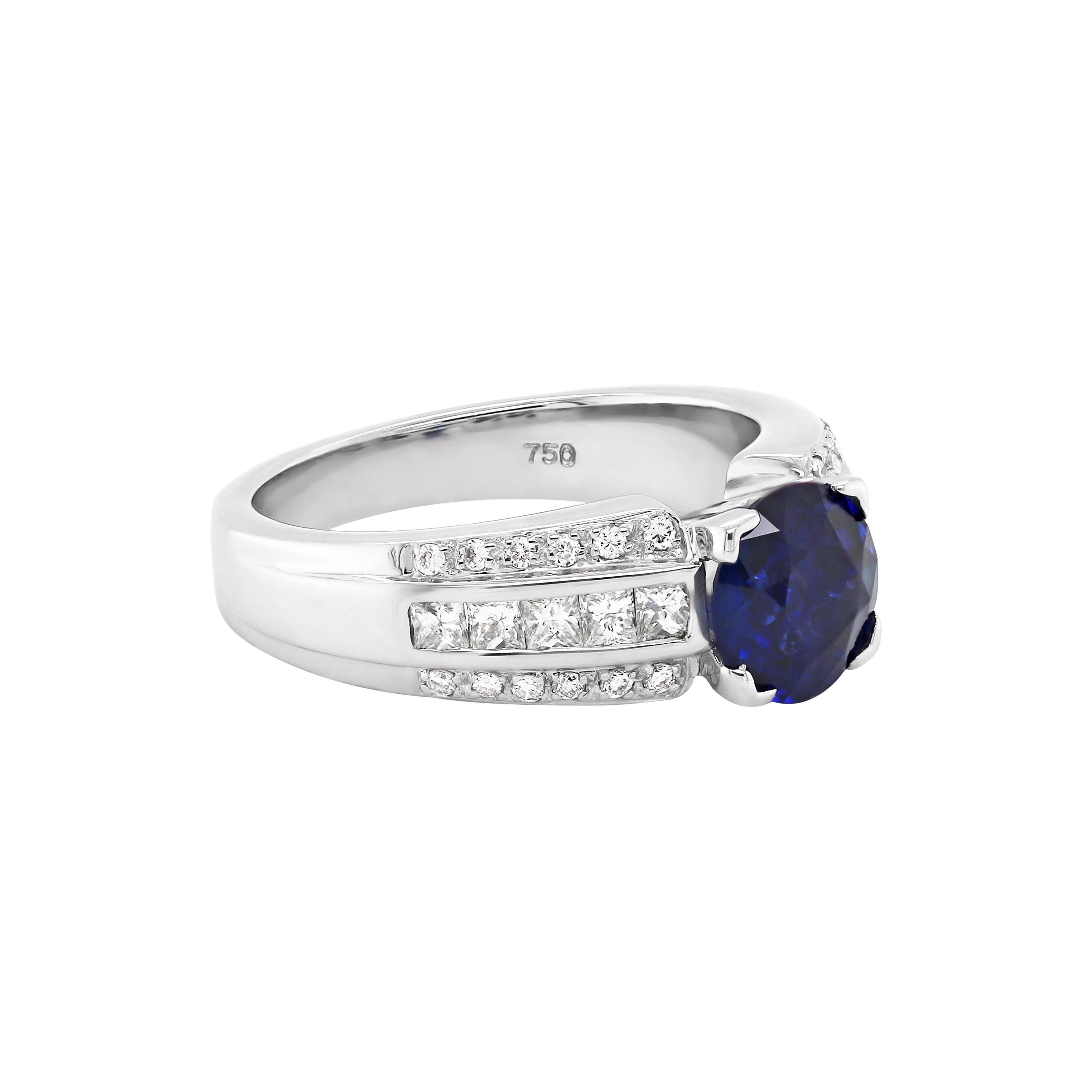 This exquisite sapphire and diamond engagement ring features a beautiful 1.81ct round shaped sapphire in the centre, in a four claw, open back setting. The sapphire is accompanied by three rows of diamonds on either side, with an approximate weight