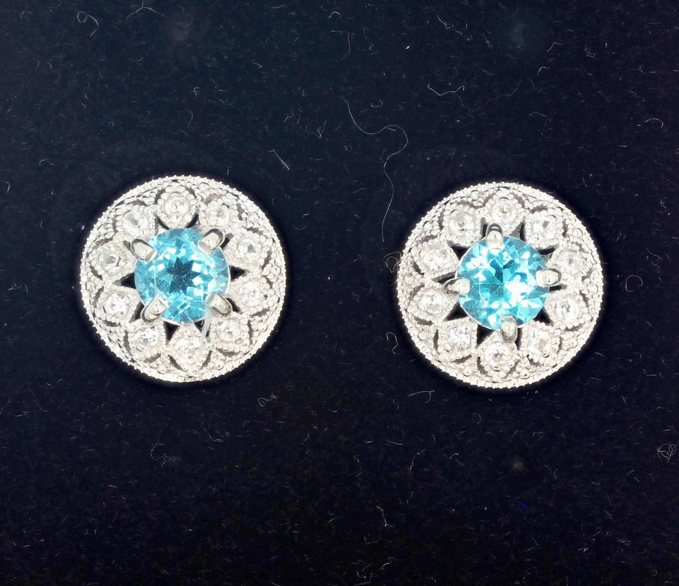 Brilliant blue round 1.82 carat Topaz (6 mm) enhanced with teeny tiny little white Diamonds set in rhodium (platinum) plated sterling silver stud earrings.  The earrings are approximately 13.5 mm.  These glitter day and night. If you wish faster