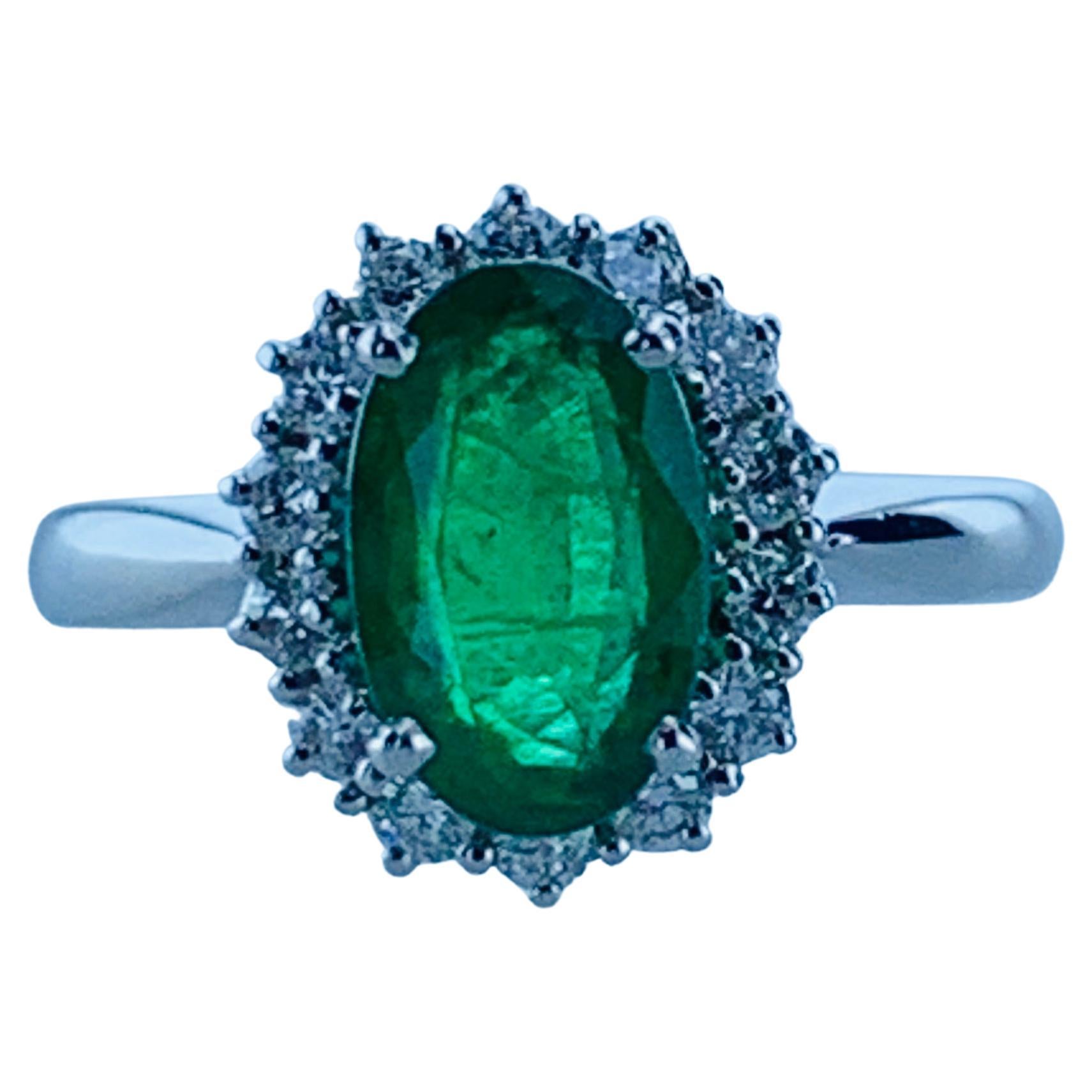 This Colombian Emerald 1.82 Carats and 0.37 Carat Diamond Halo Ring is set in 18Kt white Gold. It is bright and adds glamour and beauty to any finger. 
The circular Emerald sits within a halo of mini white bright Diamonds, giving a classic but fresh