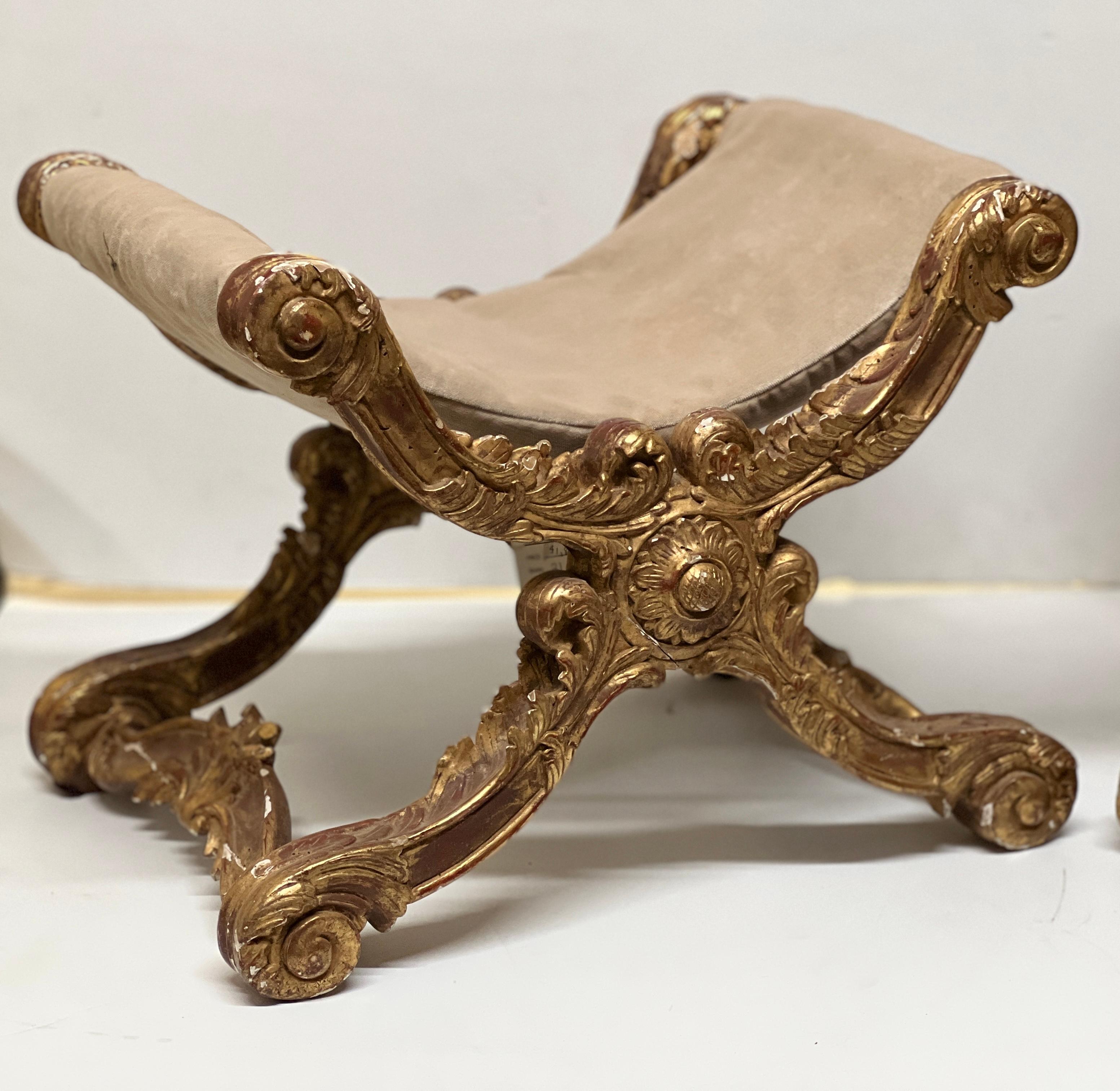 Truly stunning and one of a kind, rare collectors piece to add to their home. This pair of 1820 Italian giltwood stools are absolutely exquisite with the detailed carving on the giltwood. These both feature a soft neutral tone velvet sling