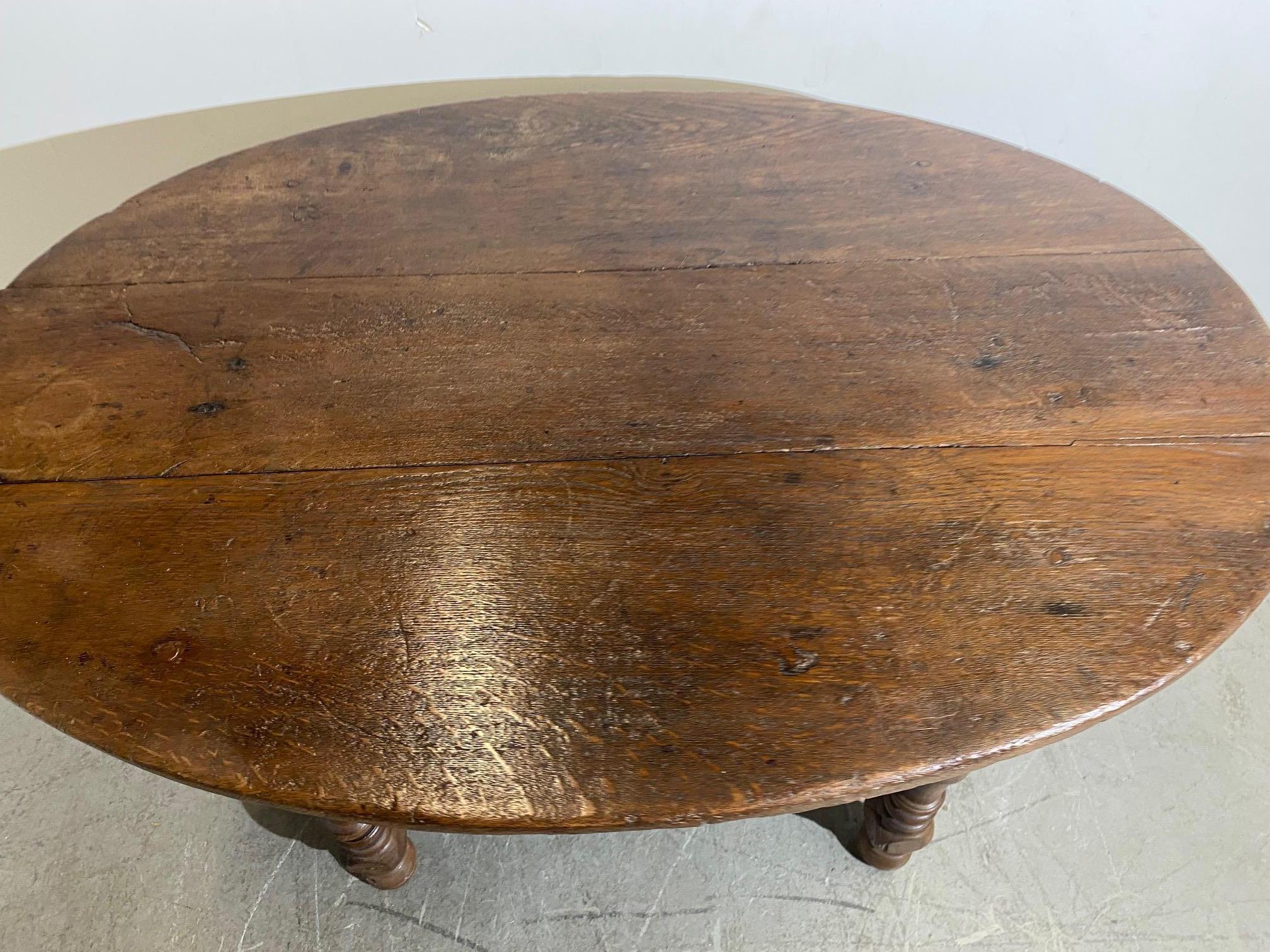 An early oval-shaped table with a solid 3-pank. Finely turned legs and stretchers. Age shows well from the underside. 