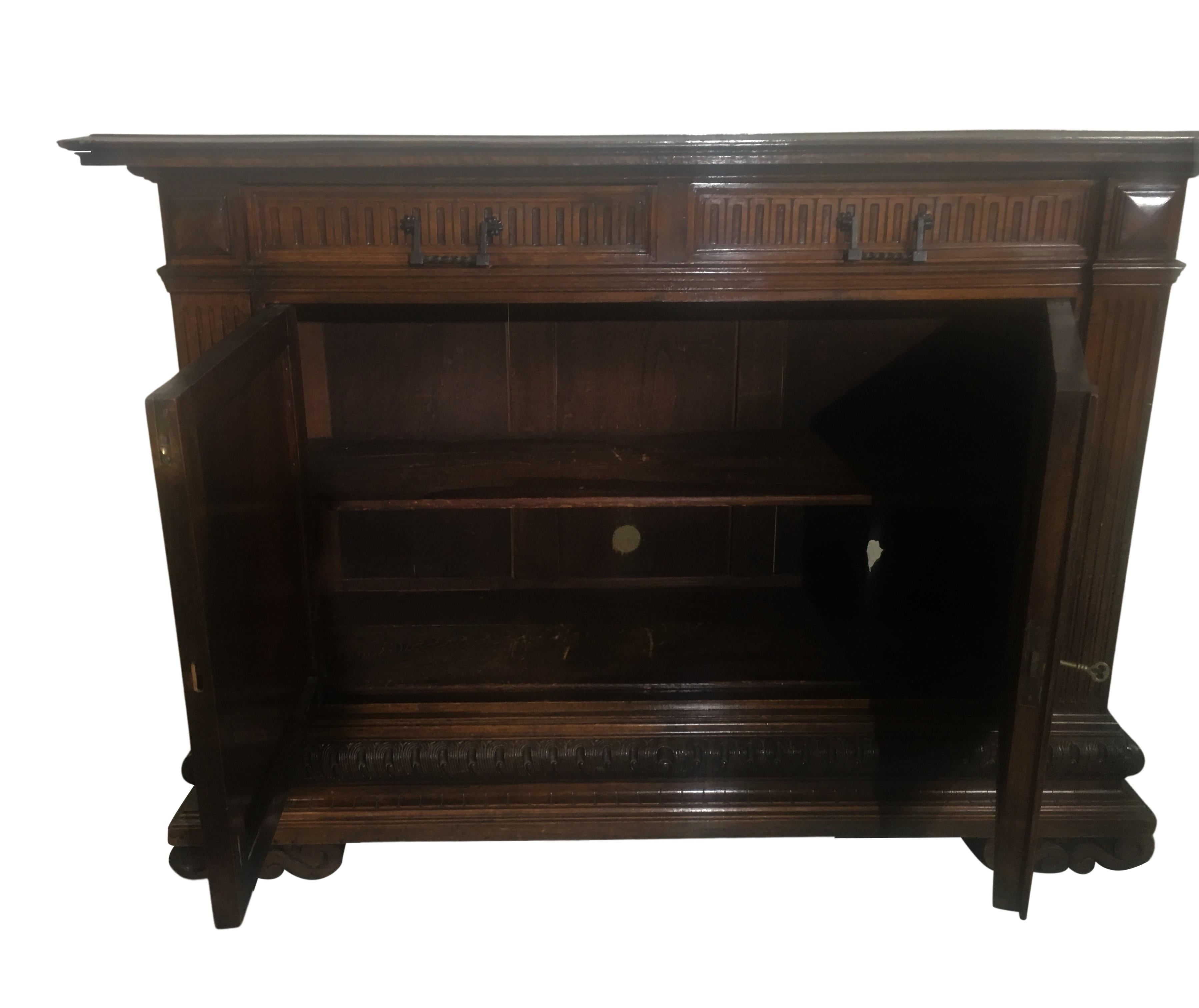 Early 19th century Italian buffett. The buffet has carvings has on the feet, bottom edge, and around the drawers. It has two drawers and two doors open up to a single shelf.