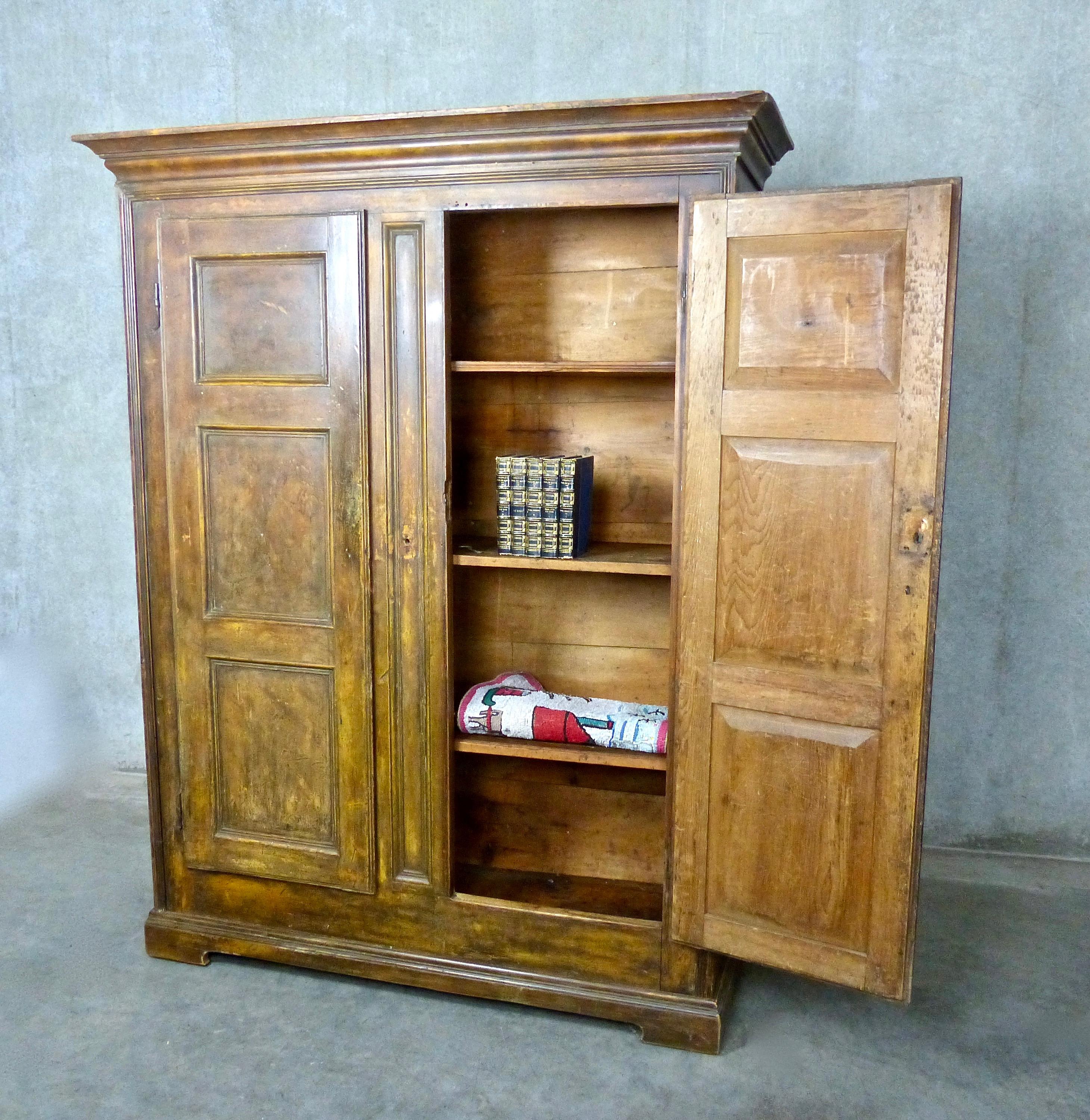 19th century six-paneled Quebec armoire with original ‘rat-tail’ hinges. Hand painted 200 years ago with a faux burled oak hand painted finish over pine wood. Three original interior shelves. Use as an armoire, library, or linen cabinet.